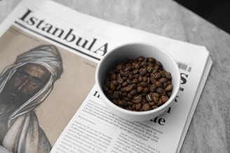 A cup of coffee sitting on top of a newspaper