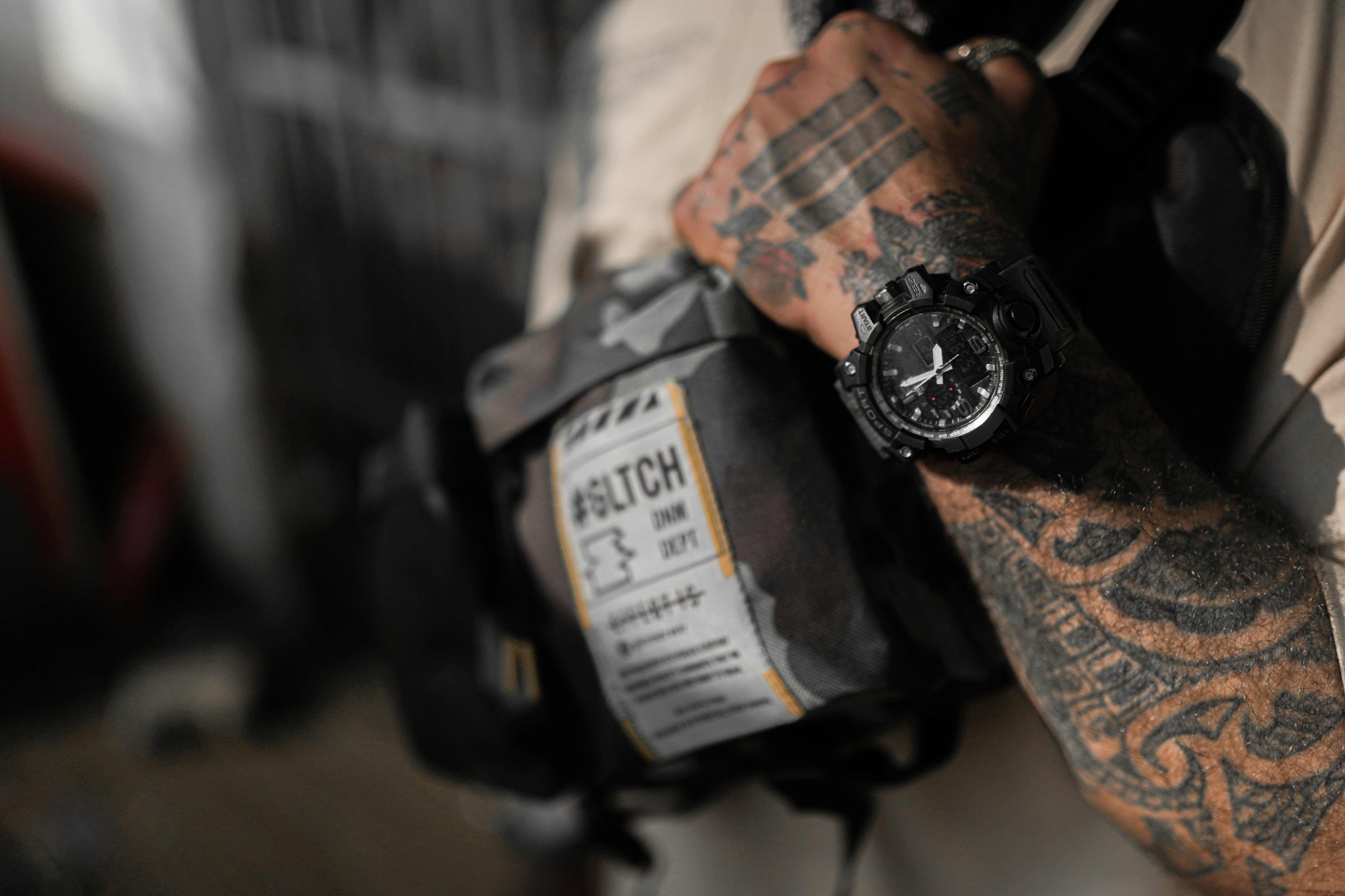 A man with a tattoo on his arm holding a camera