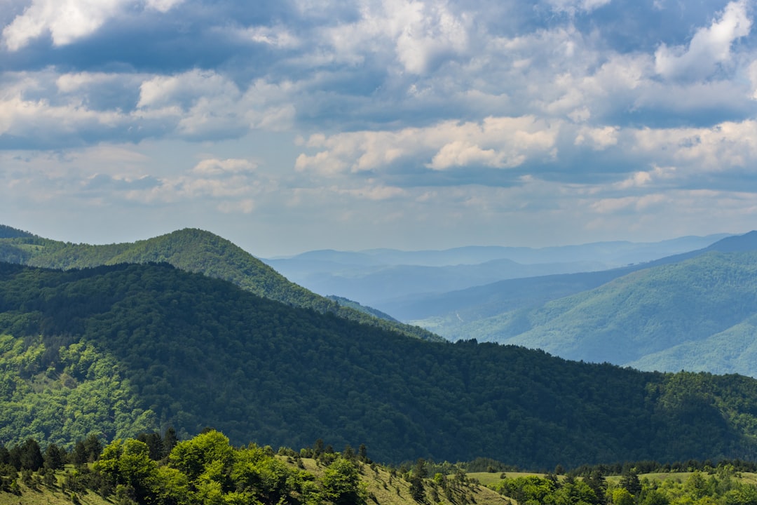 A scenic view of a mountain range with clouds in the sky,