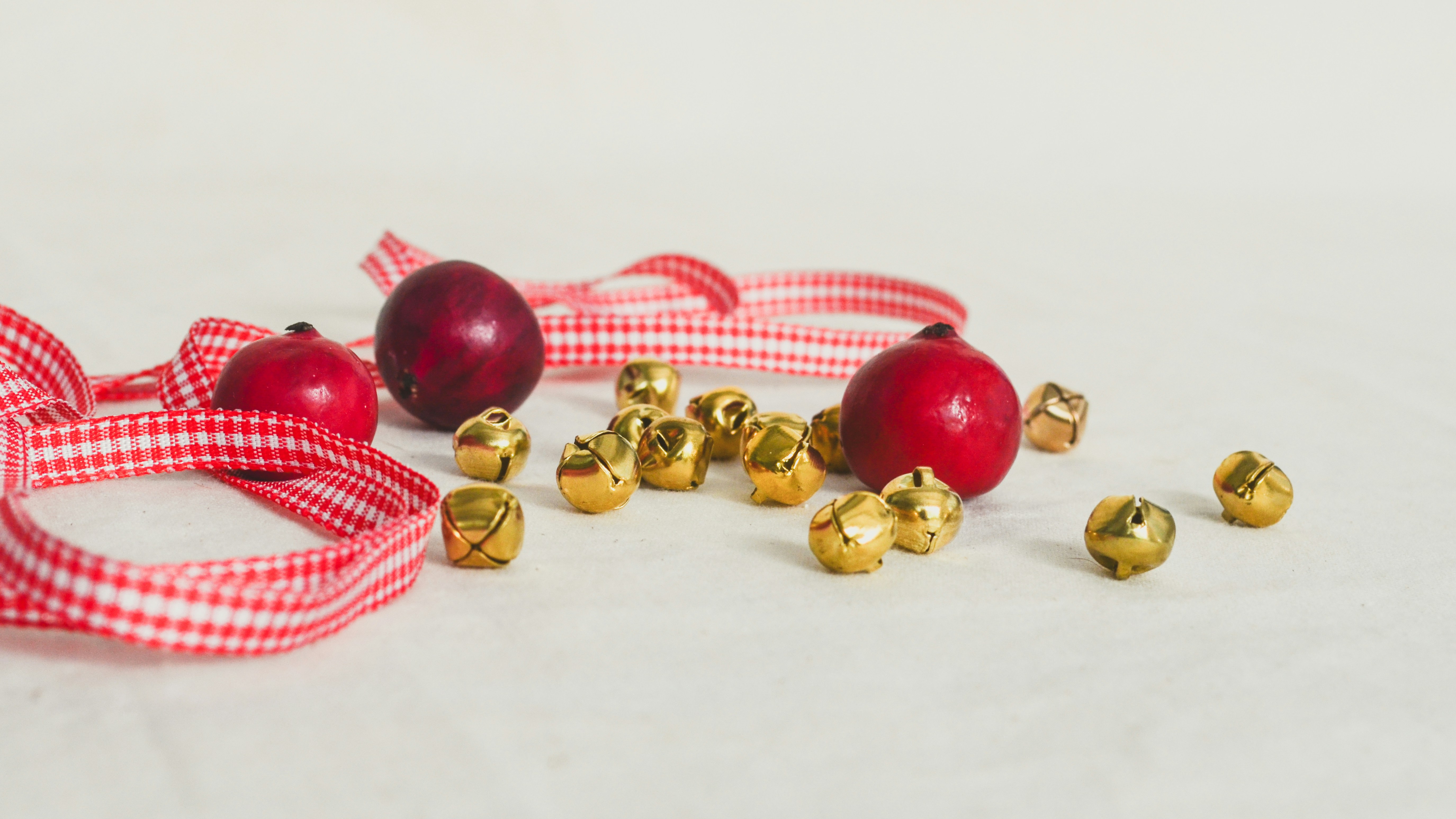 A red and white checkered ribbon and some gold bells