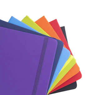 A bunch of different colored notebooks stacked on top of each other