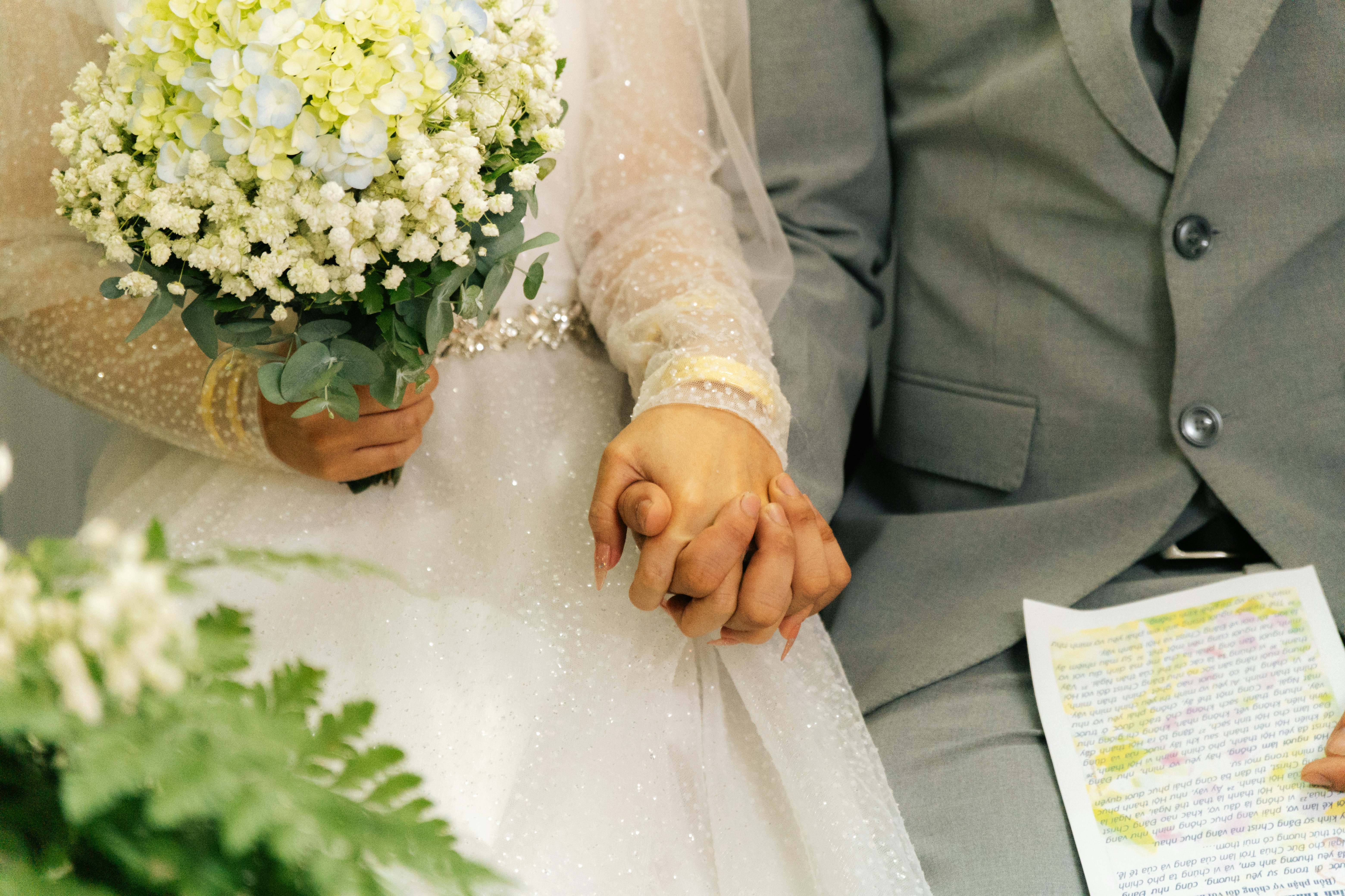 Wedding rings flowers, Wedding planner notebook, Couple holding hands, ilustrasi artikel Stress-Free Wedding Budgeting: Your Ultimate Guide to a Joyful Day 1