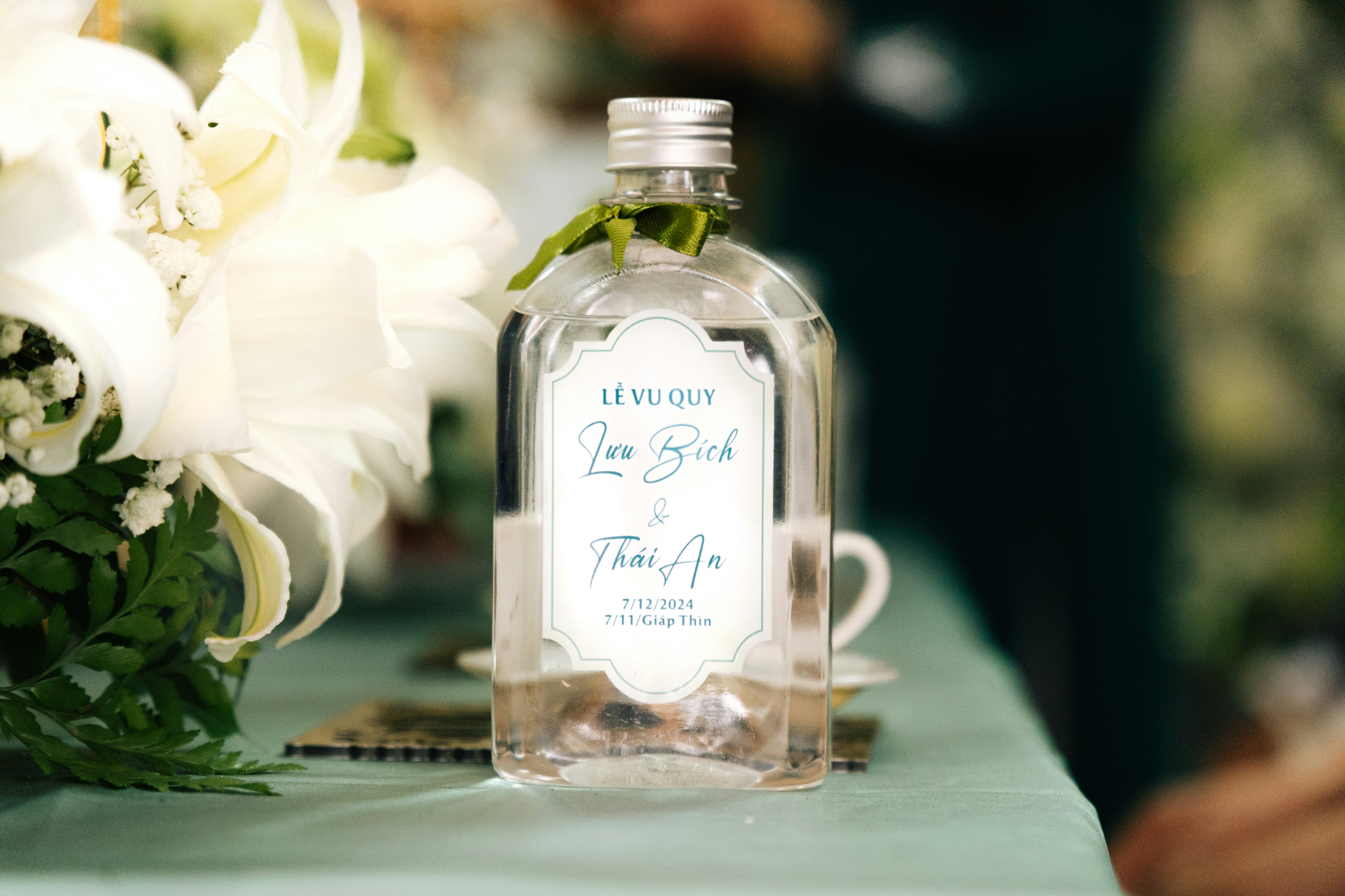 Une bouteille d’alcool posée à côté d’un bouquet de fleurs