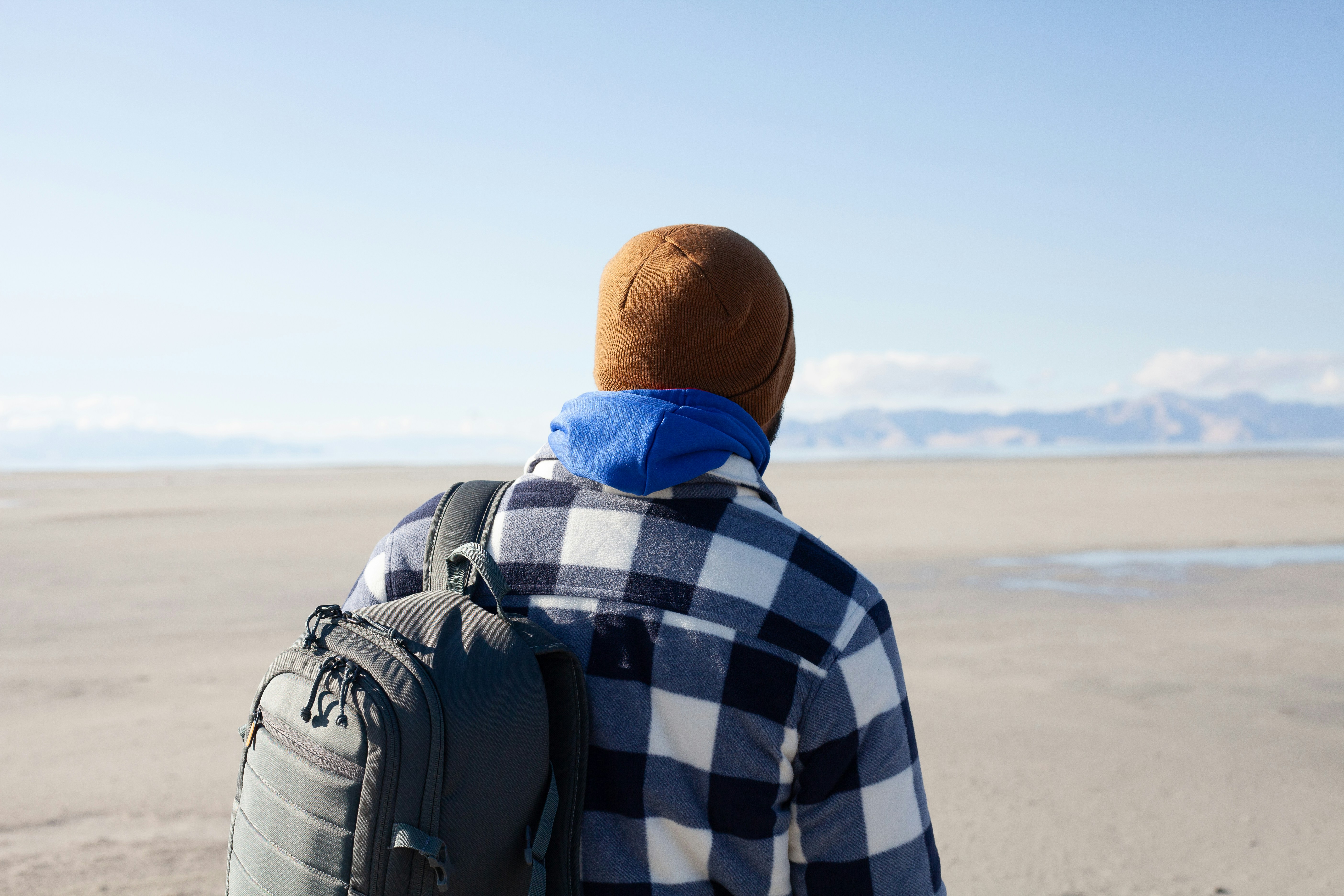 A man with a backpack walking on the beach