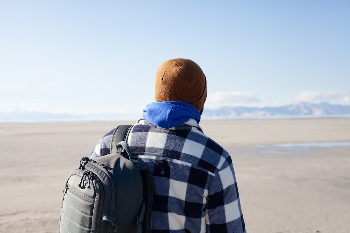 A man with a backpack walking on the beach