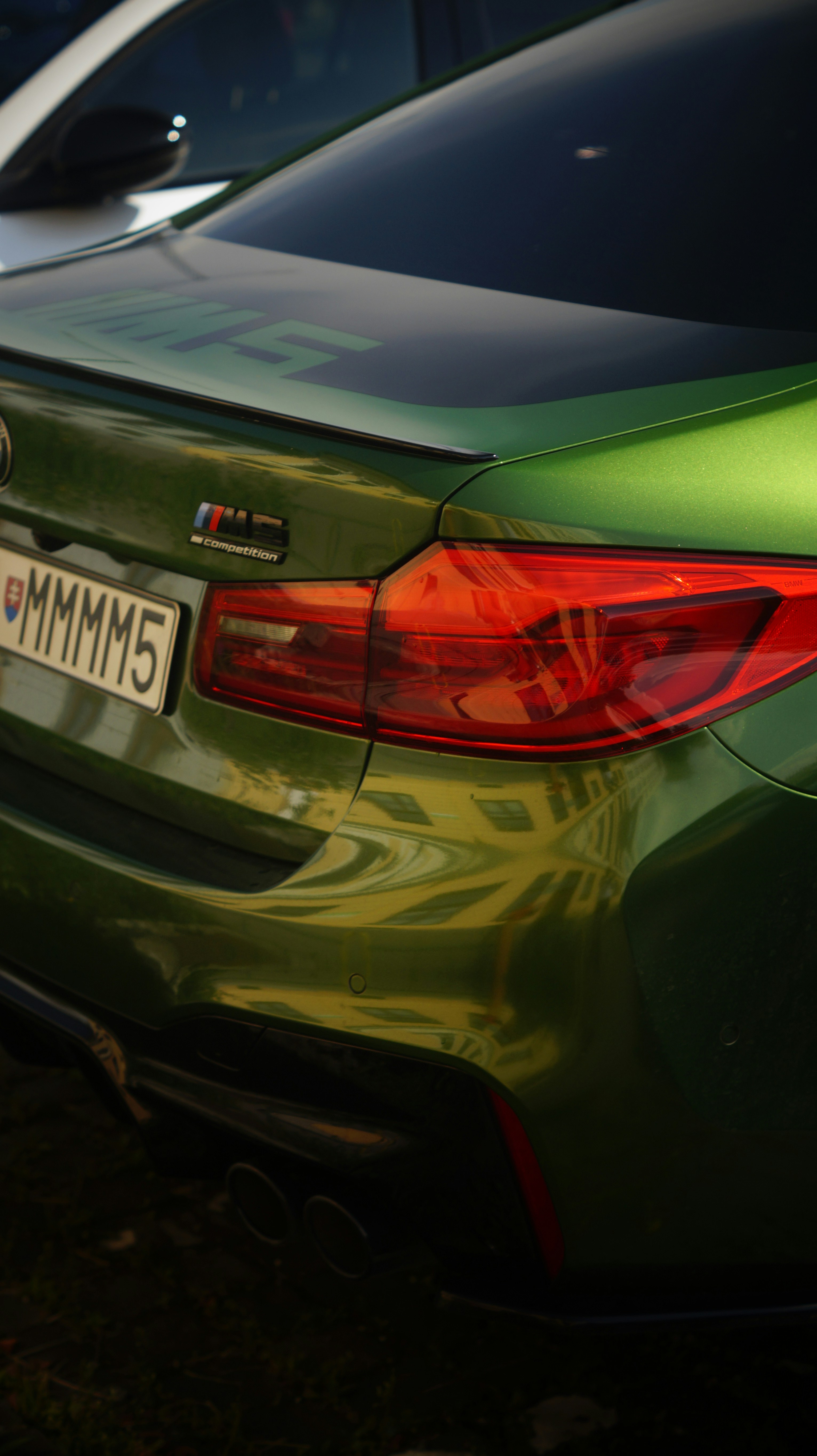 A green car parked next to a white car