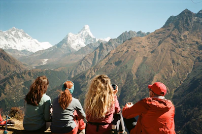 A group of people sitting on top of a mountain