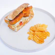 A white plate topped with a sandwich and chips