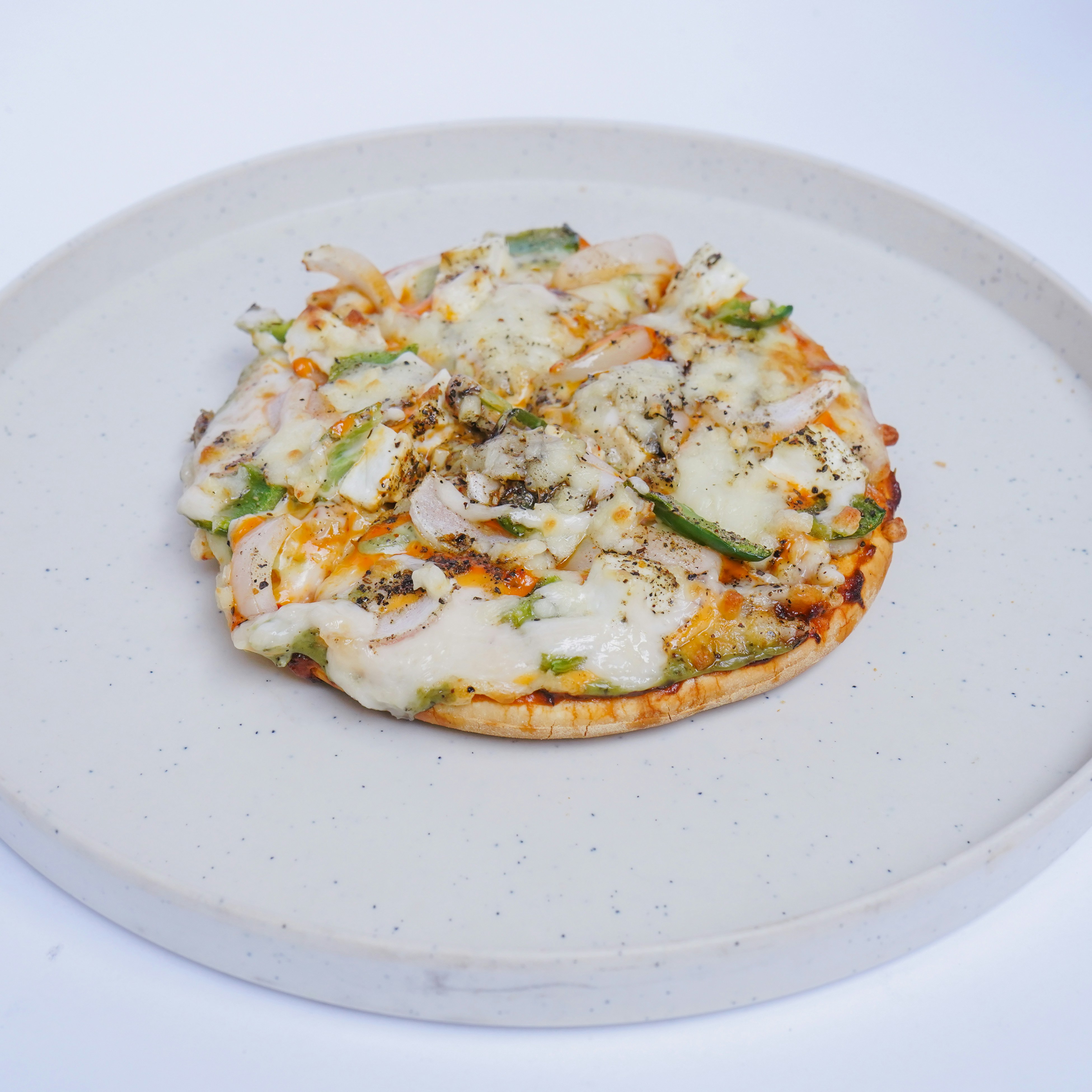 A small pizza sitting on top of a white plate