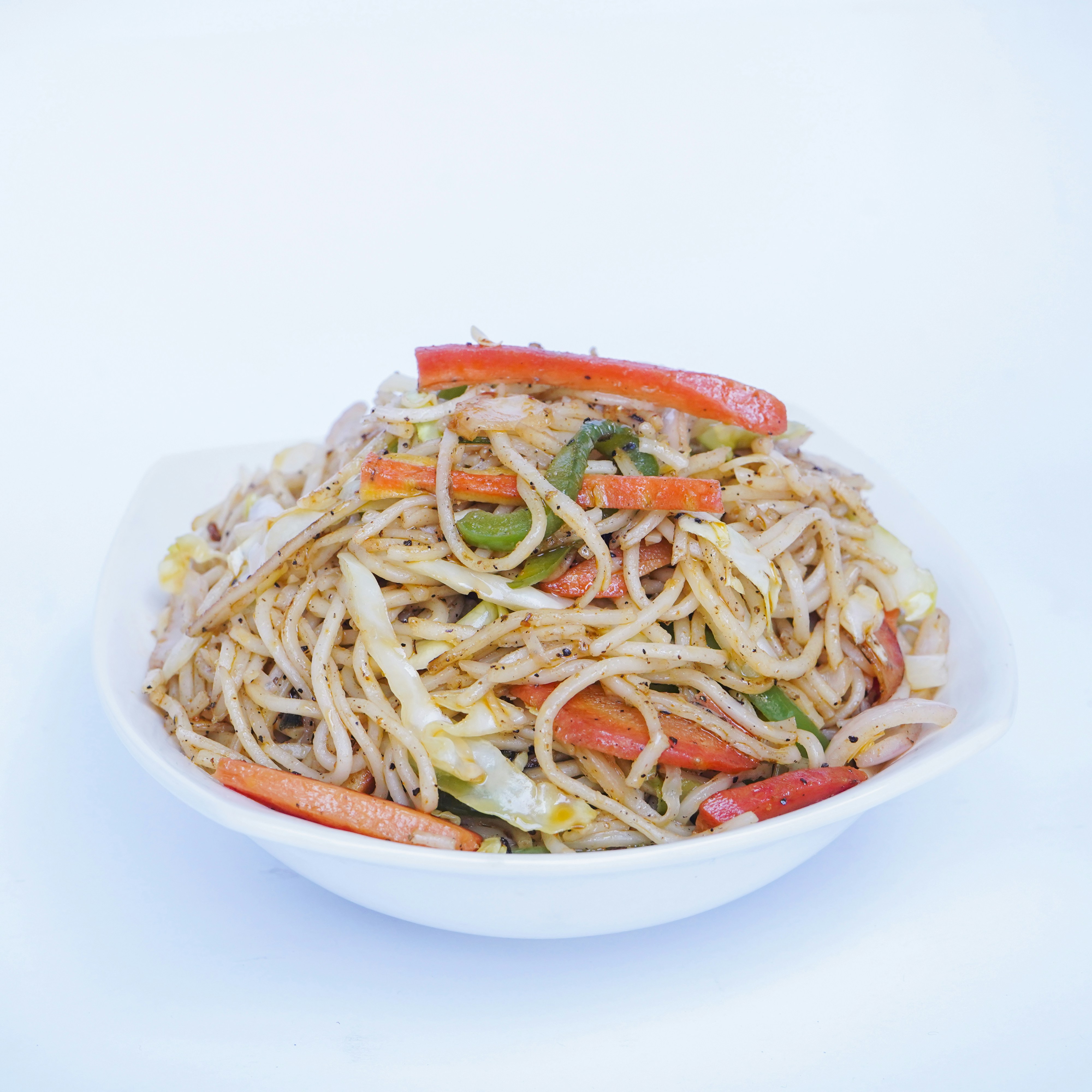 A white bowl filled with noodles and vegetables