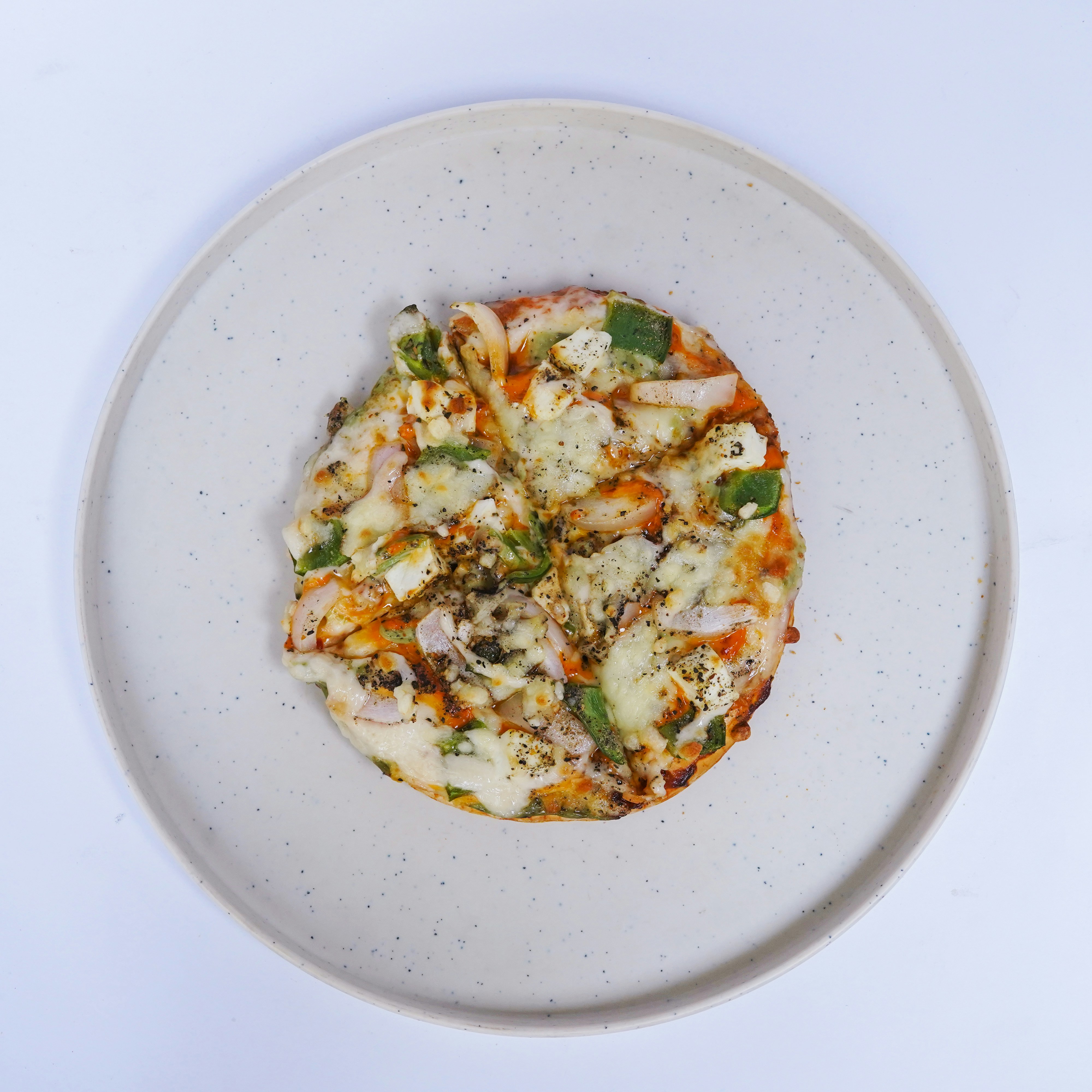 A white plate topped with a pizza covered in cheese