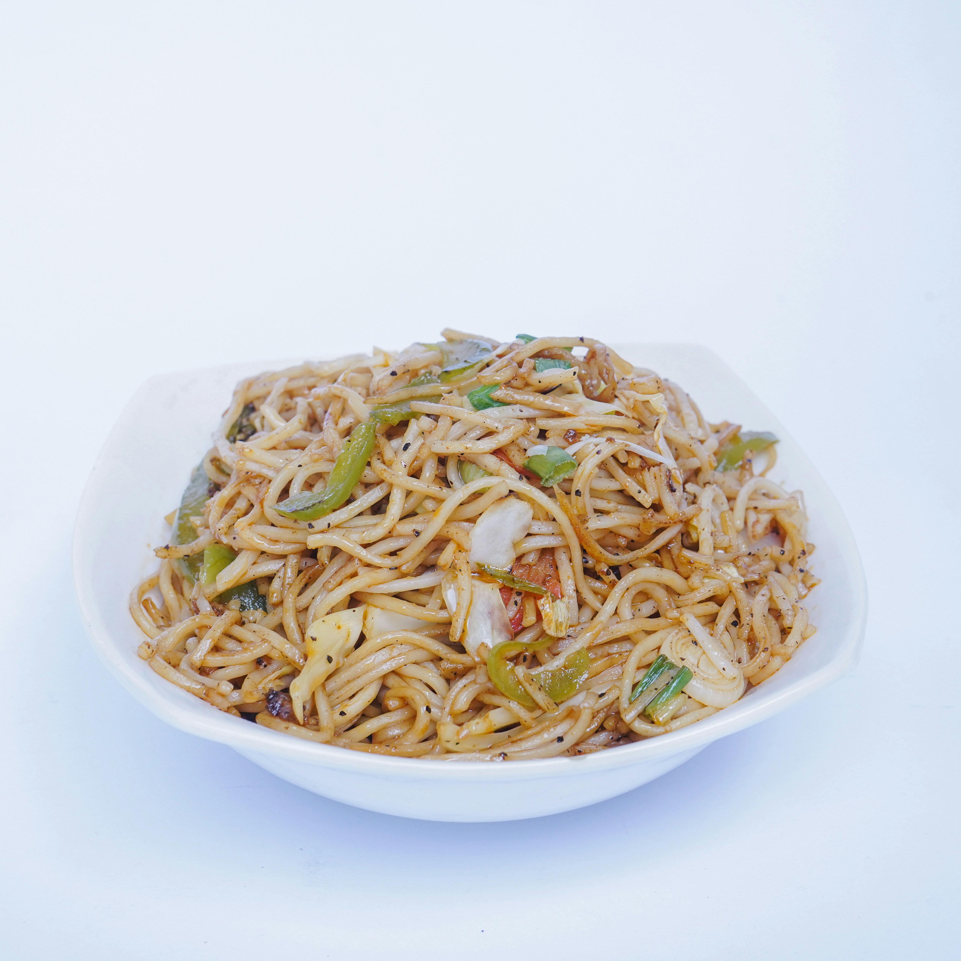 A white bowl filled with noodles and vegetables