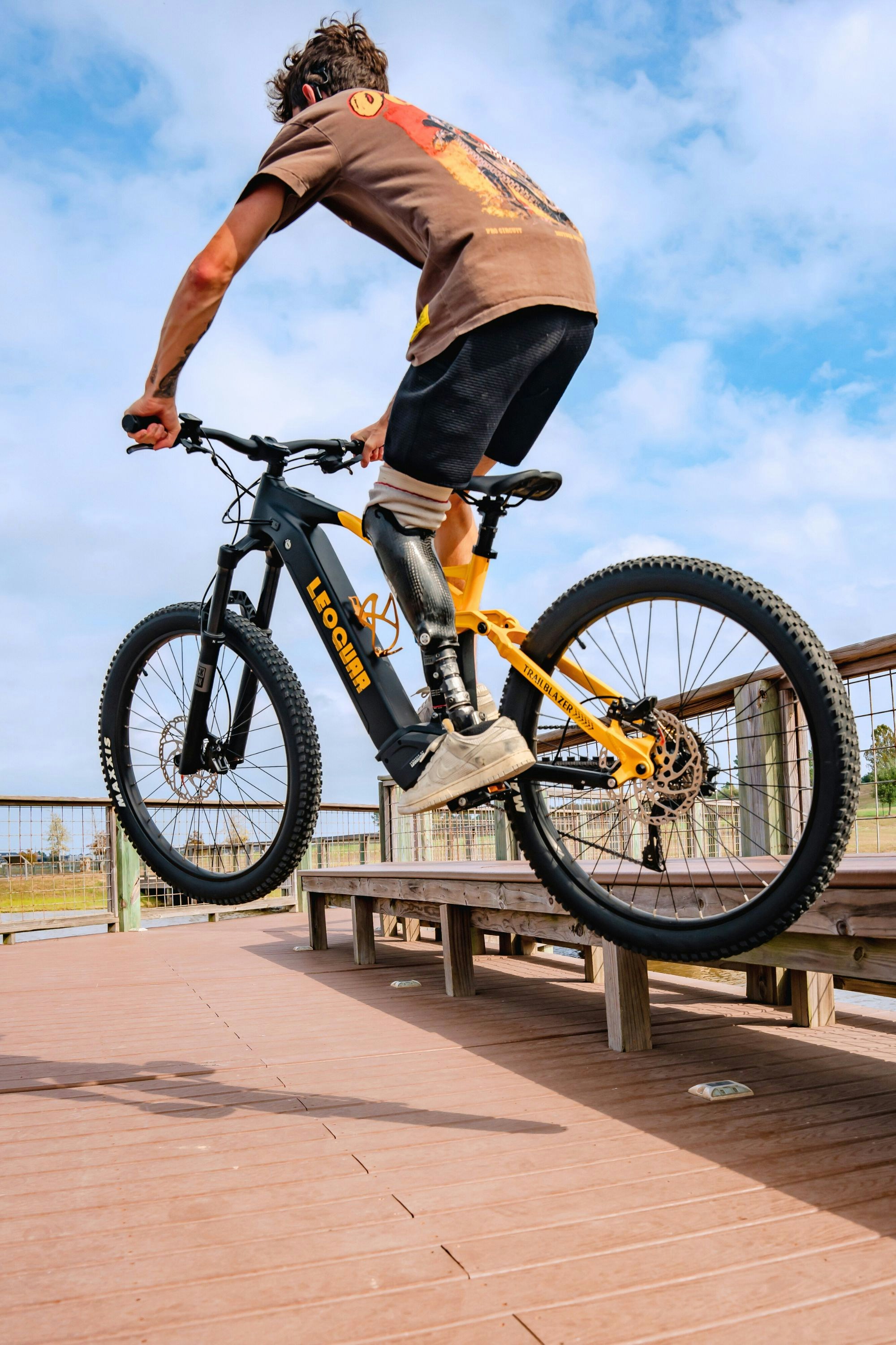 A man jumping a bike over a wooden bench