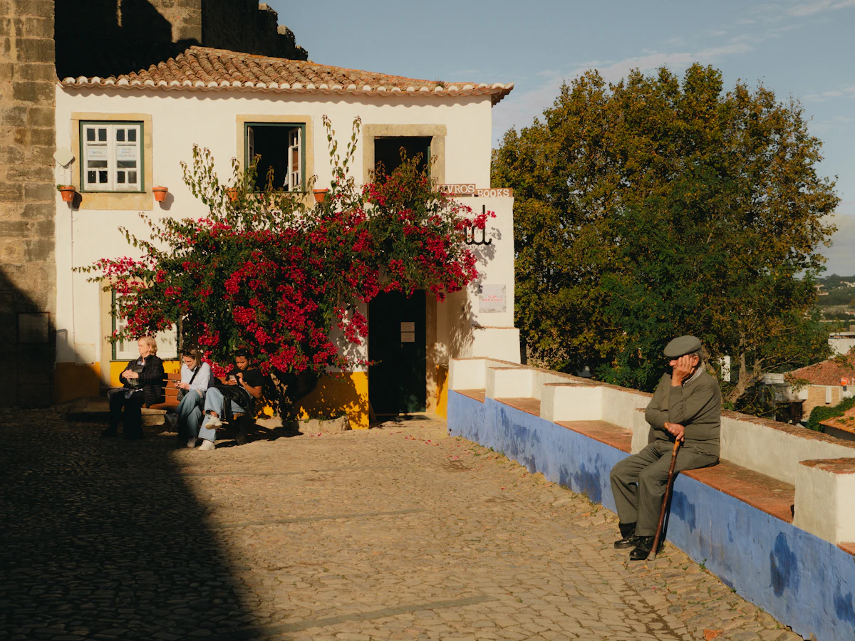 A man sitting on a ledge in front of a house