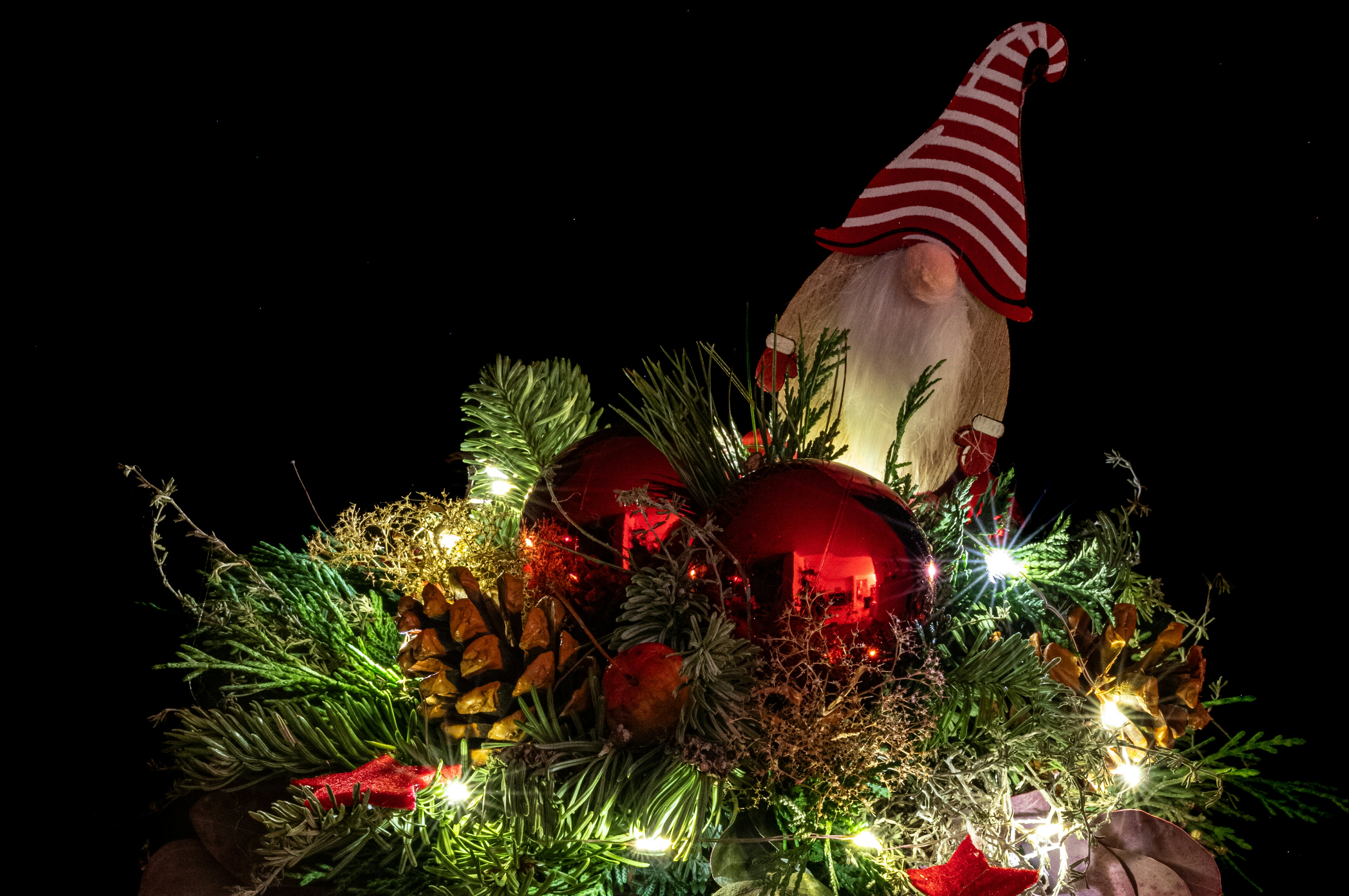 Una persona sosteniendo un árbol de Navidad decorado con adornos