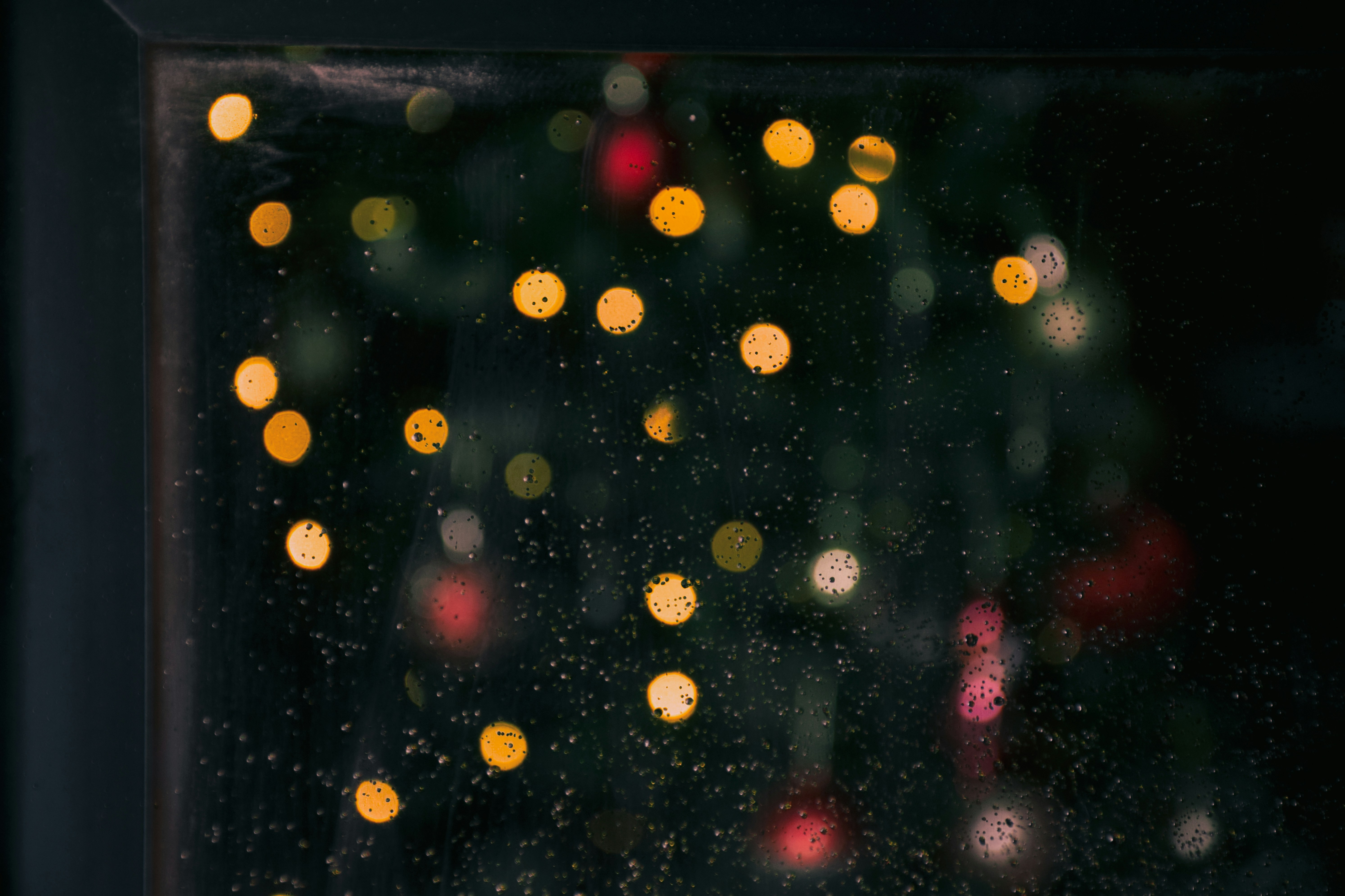 A blurry photo of a christmas tree outside a window