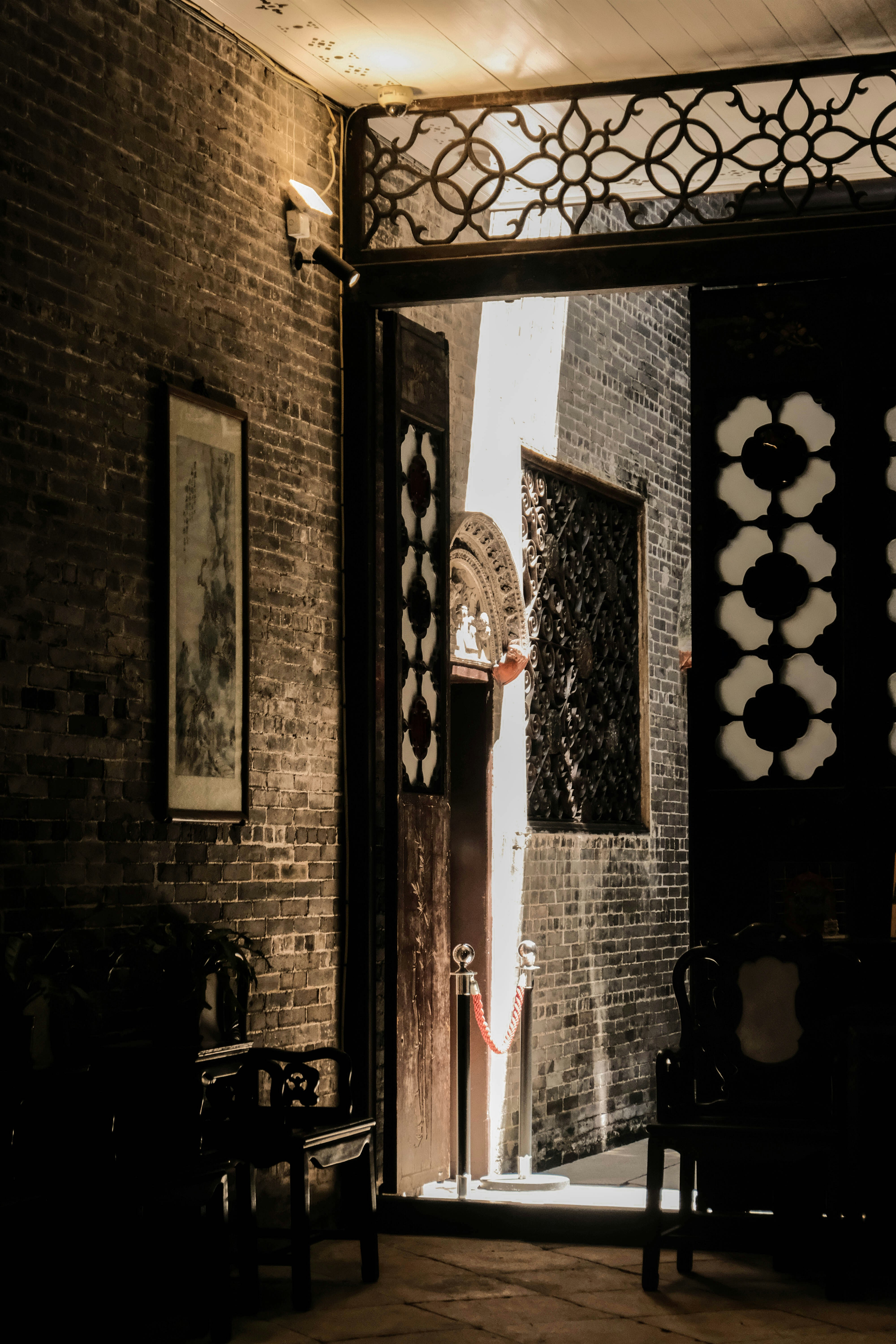 An open door leading into a room with a brick wall