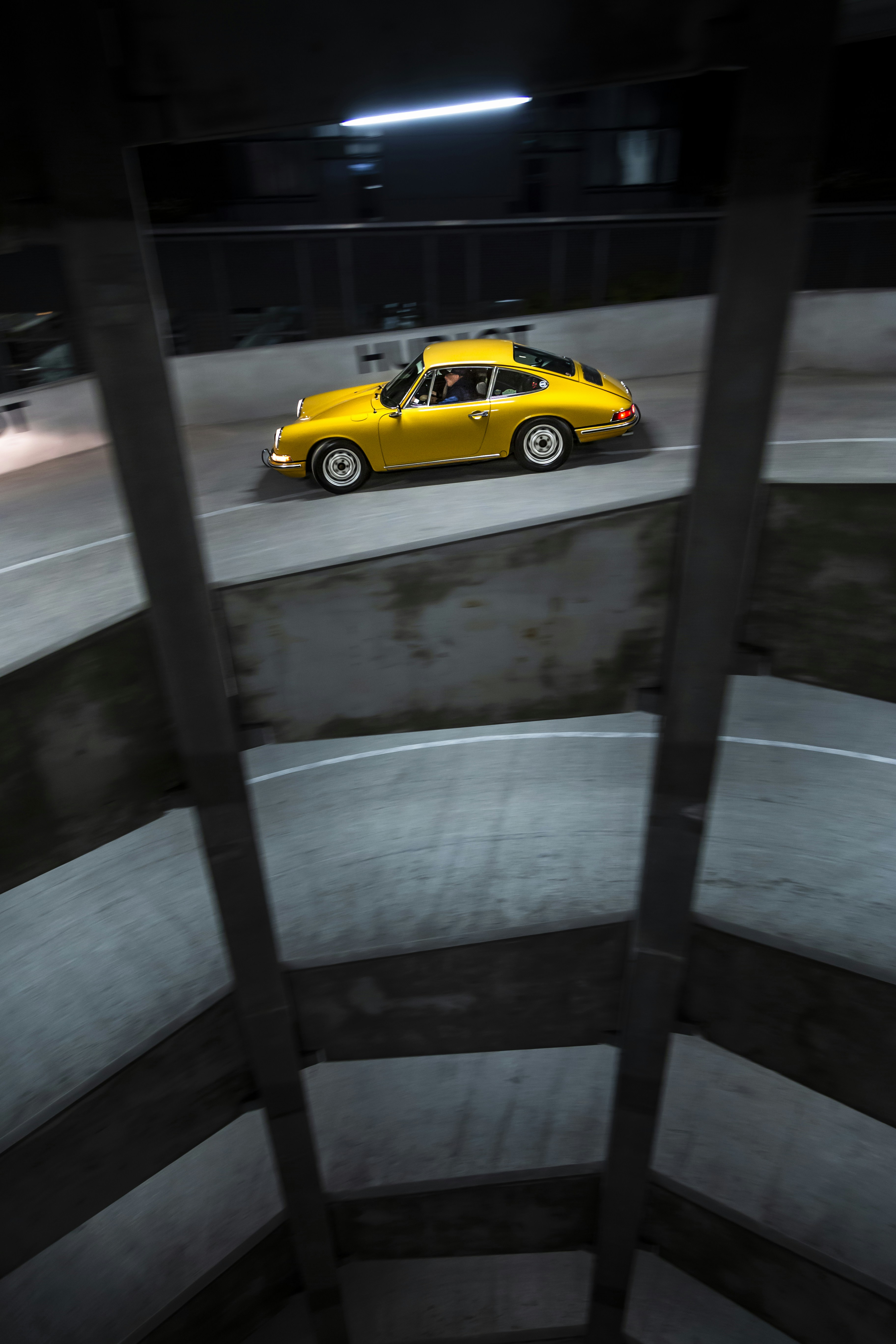 A yellow car driving down a street at night photo – Free Wallpaper ...