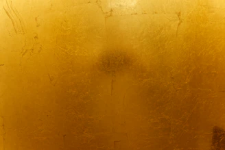 A close up of a toilet with a yellow wall