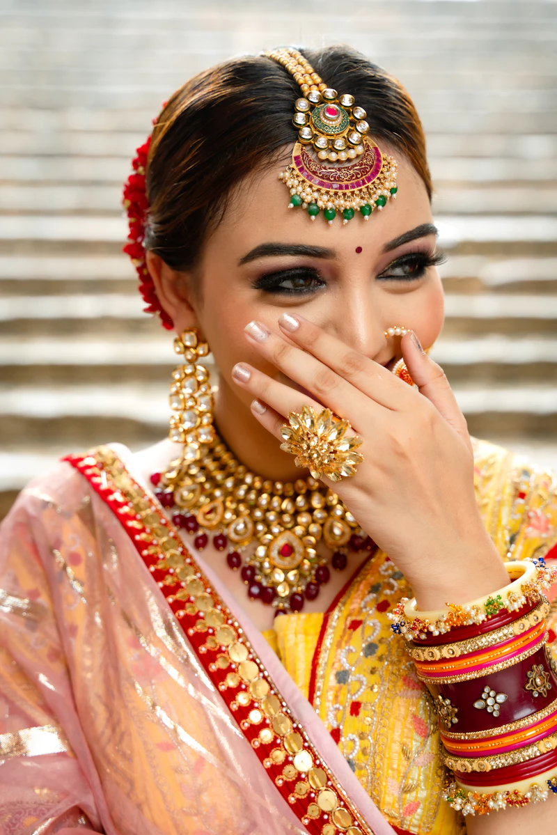 Laughing bride in a pastel lehenga and green jewellery