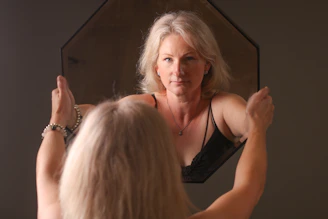 A woman standing in front of a mirror brushing her hair