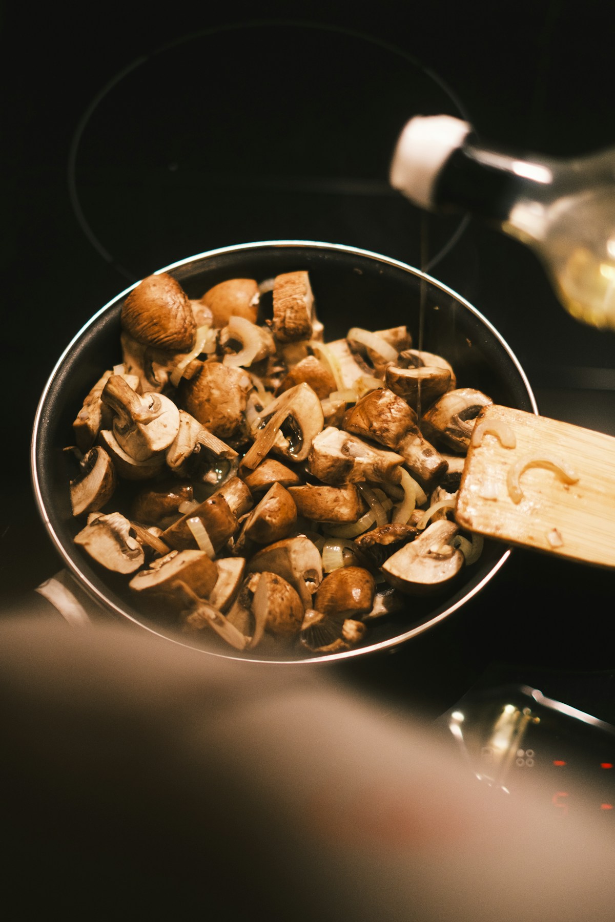 Mushrooms browning in a hot skillet on the stove