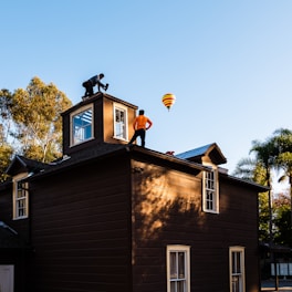 A man standing on top of a brown building