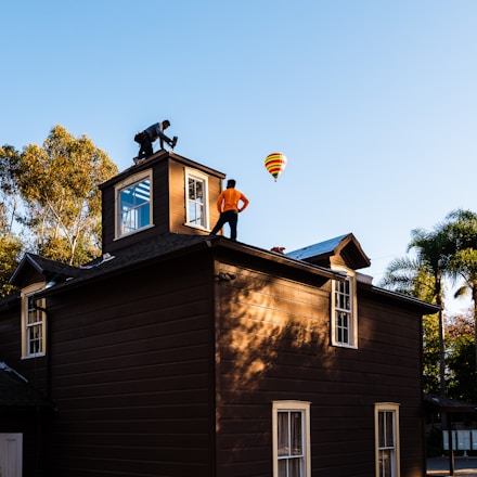 A man standing on top of a brown building