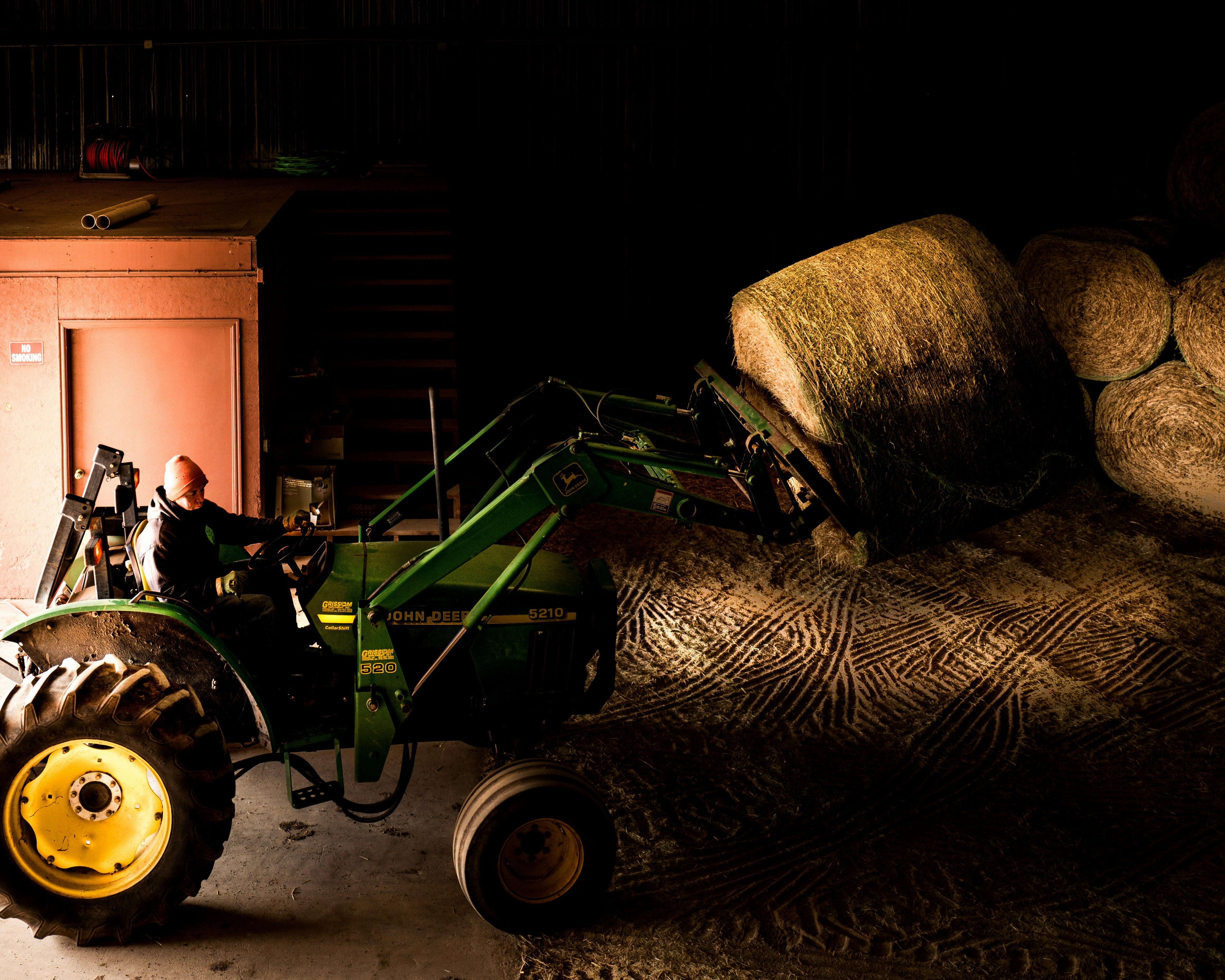 Un tracteur est garé à côté d’un tas de bûches