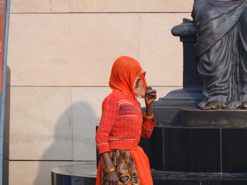 Indian sugar mama by a statue in front of a grand building