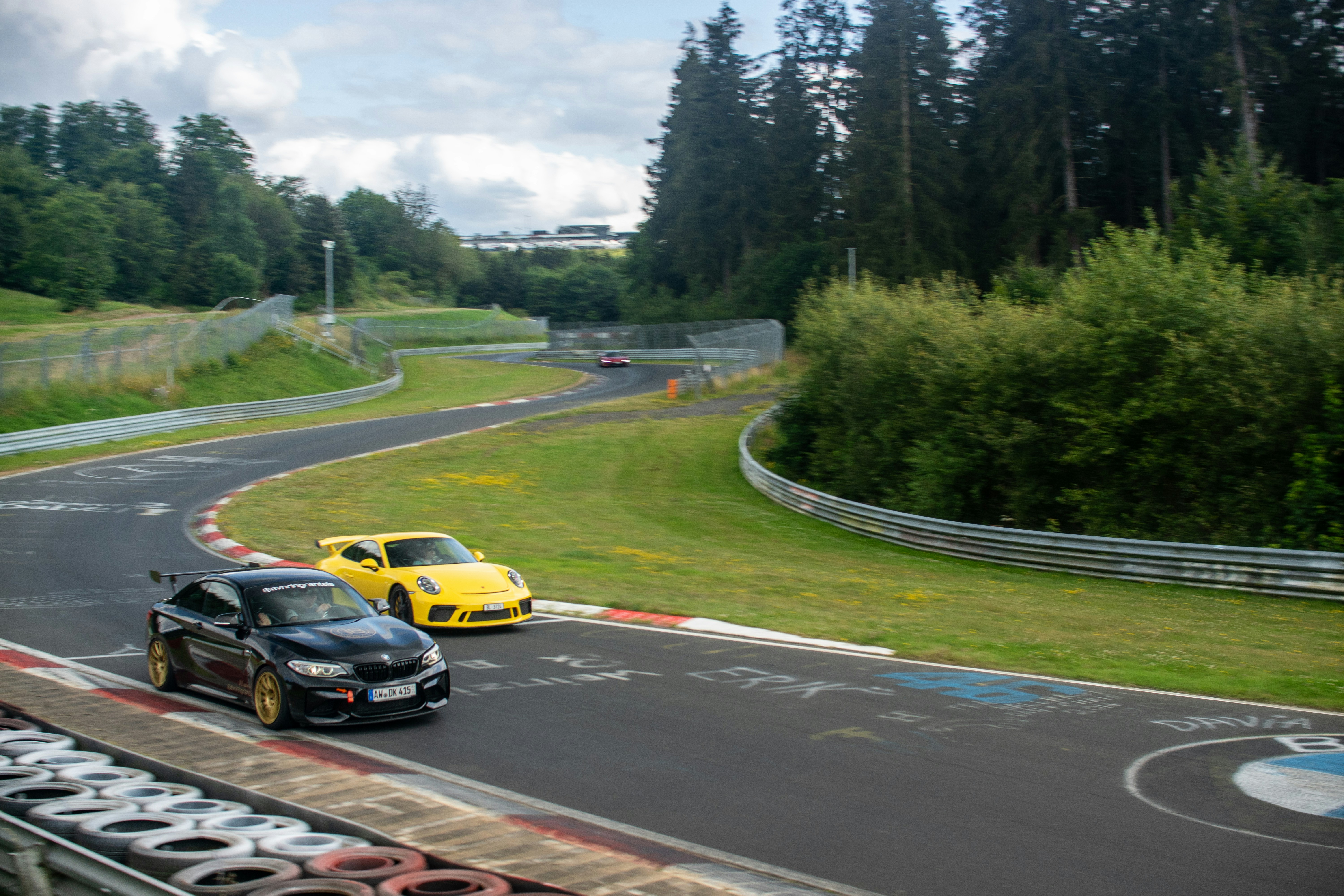 A couple of cars driving down a race track