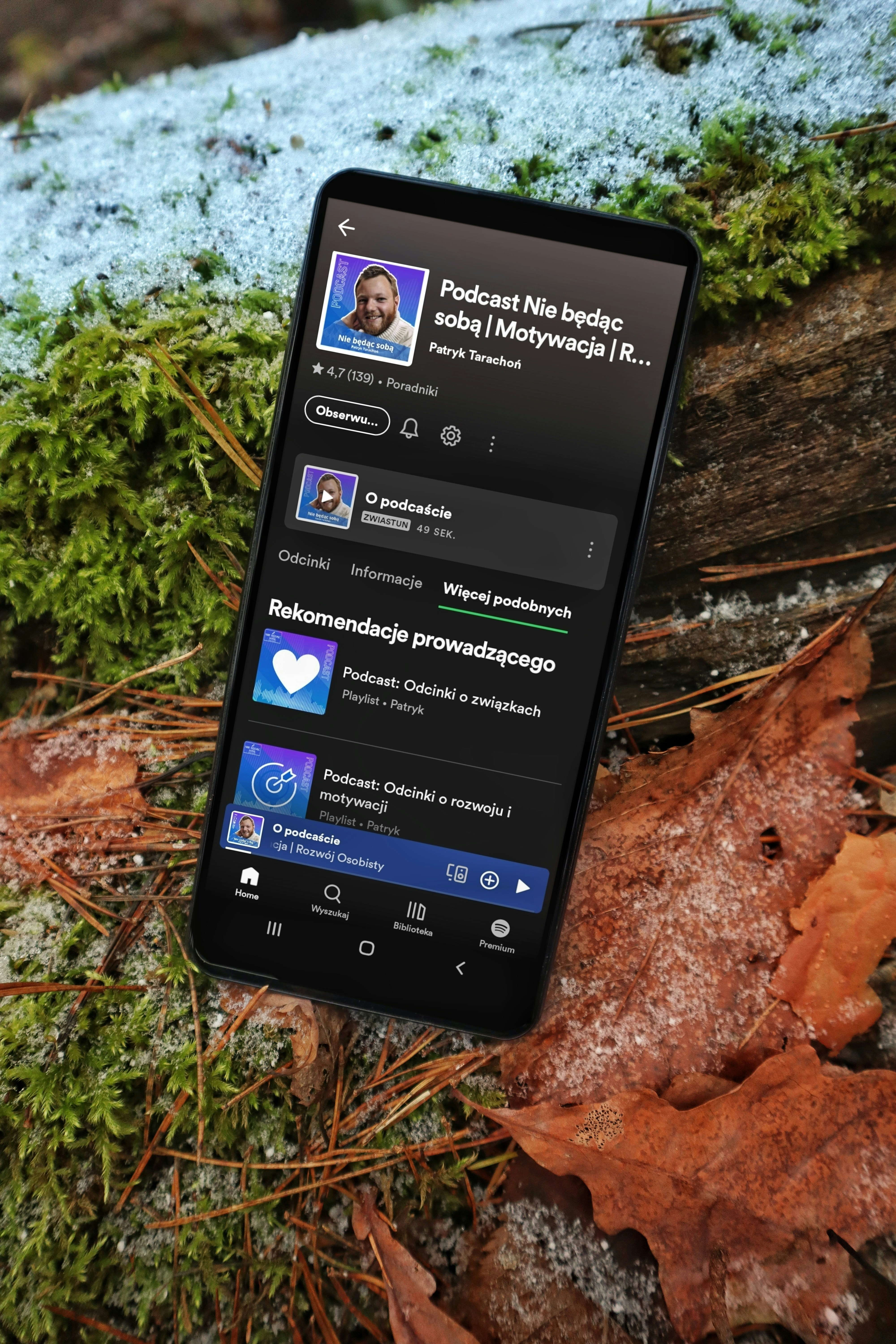 A cell phone sitting on top of a leaf covered ground