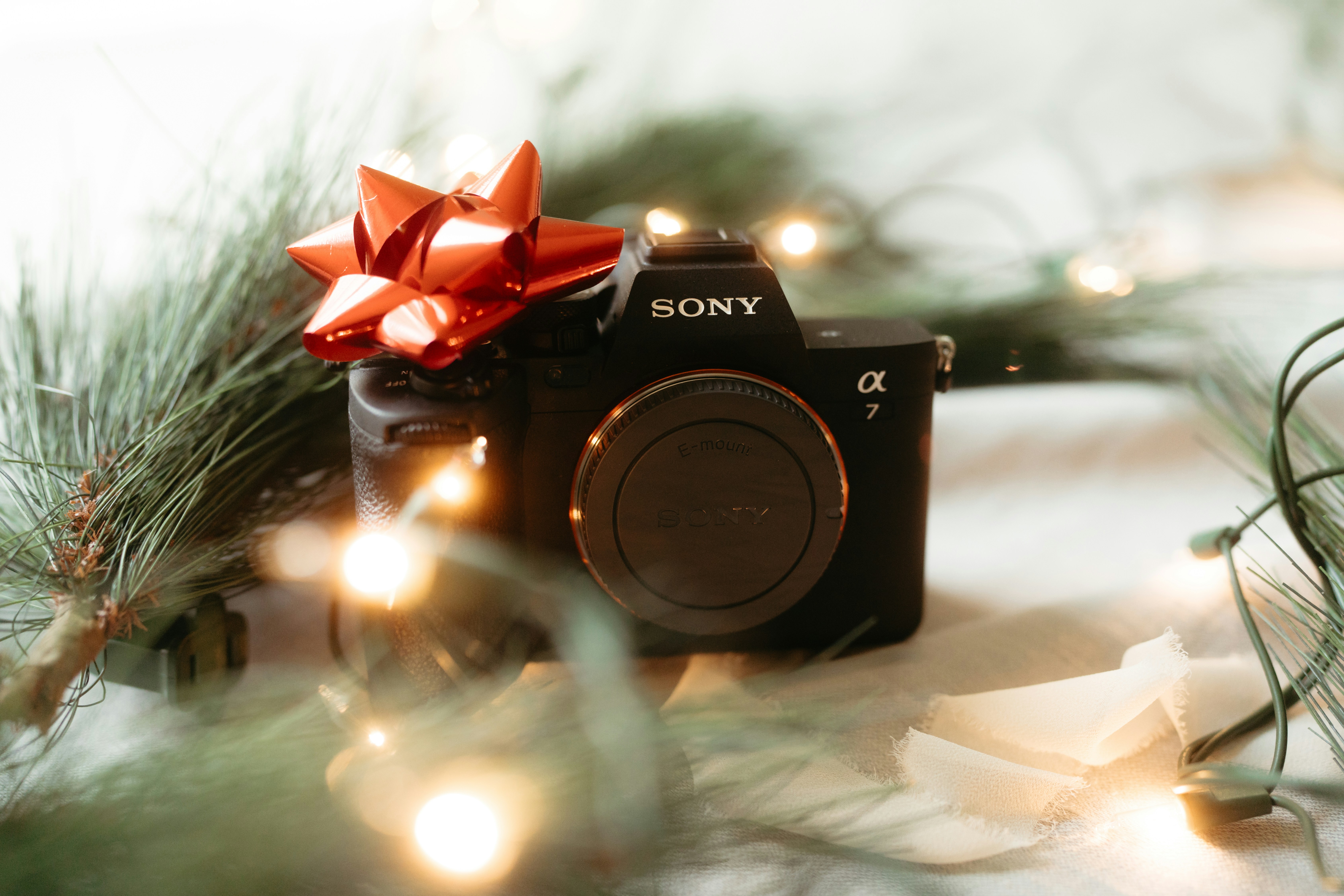 A camera sitting on top of a table next to a christmas tree