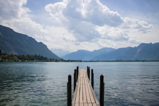A long dock extending into a lake with mountains in the background