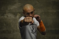 A man with a bald head pointing a finger at the camera