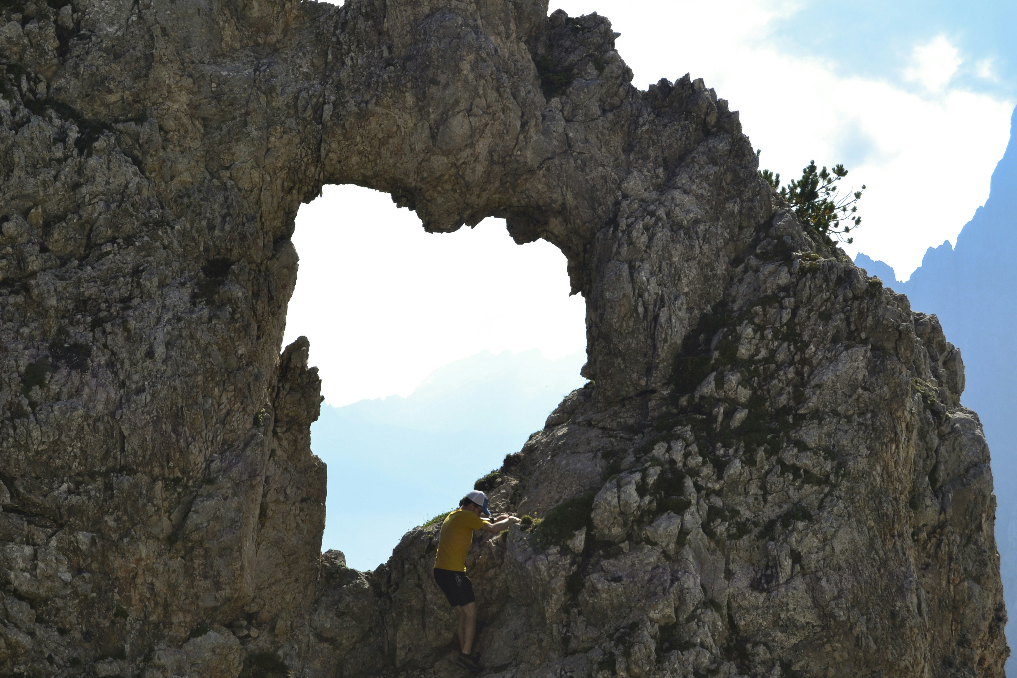 A man climbing up the side of a mountain