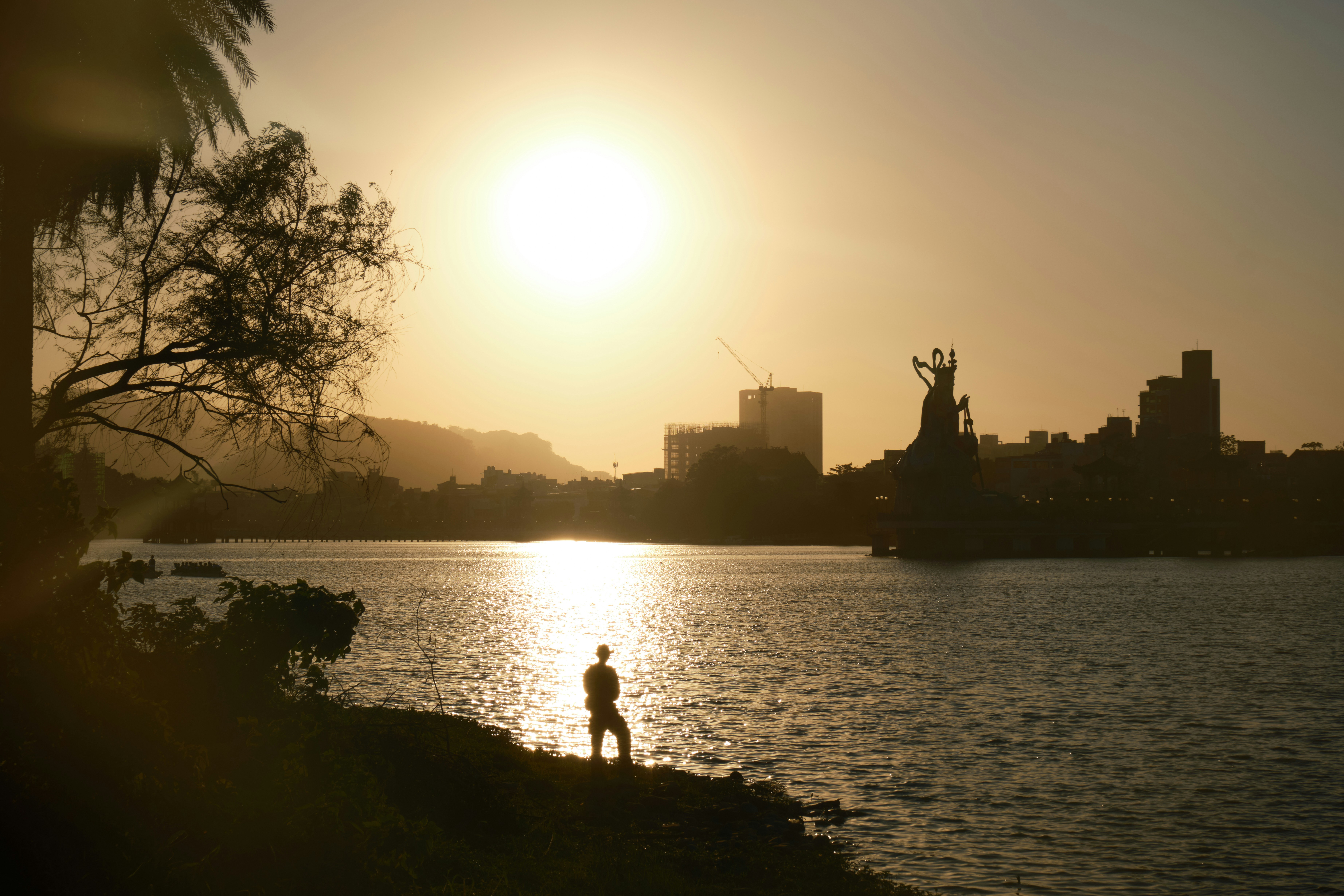 A person standing on the shore of a body of water