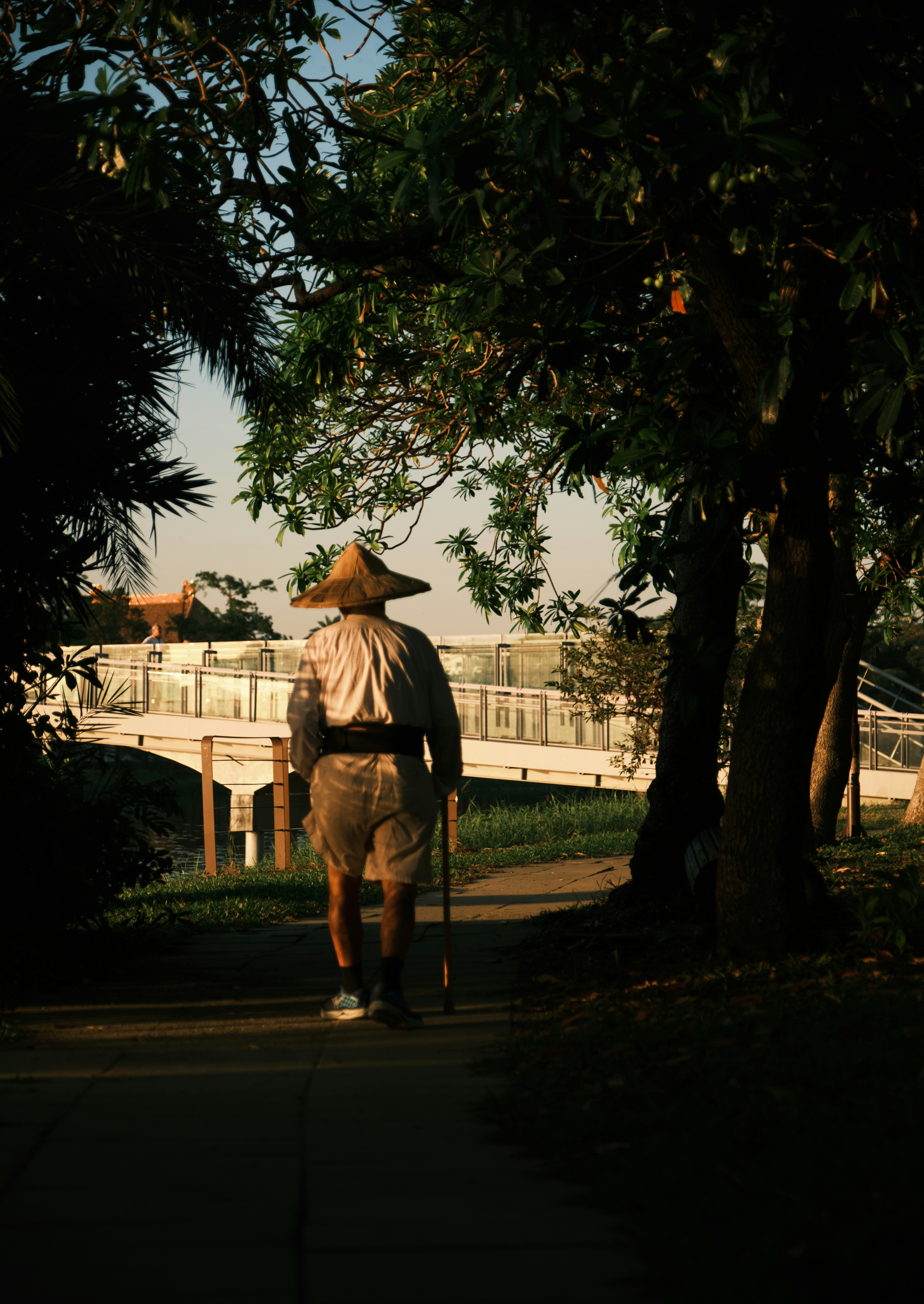 A man walking down a sidewalk with a cane