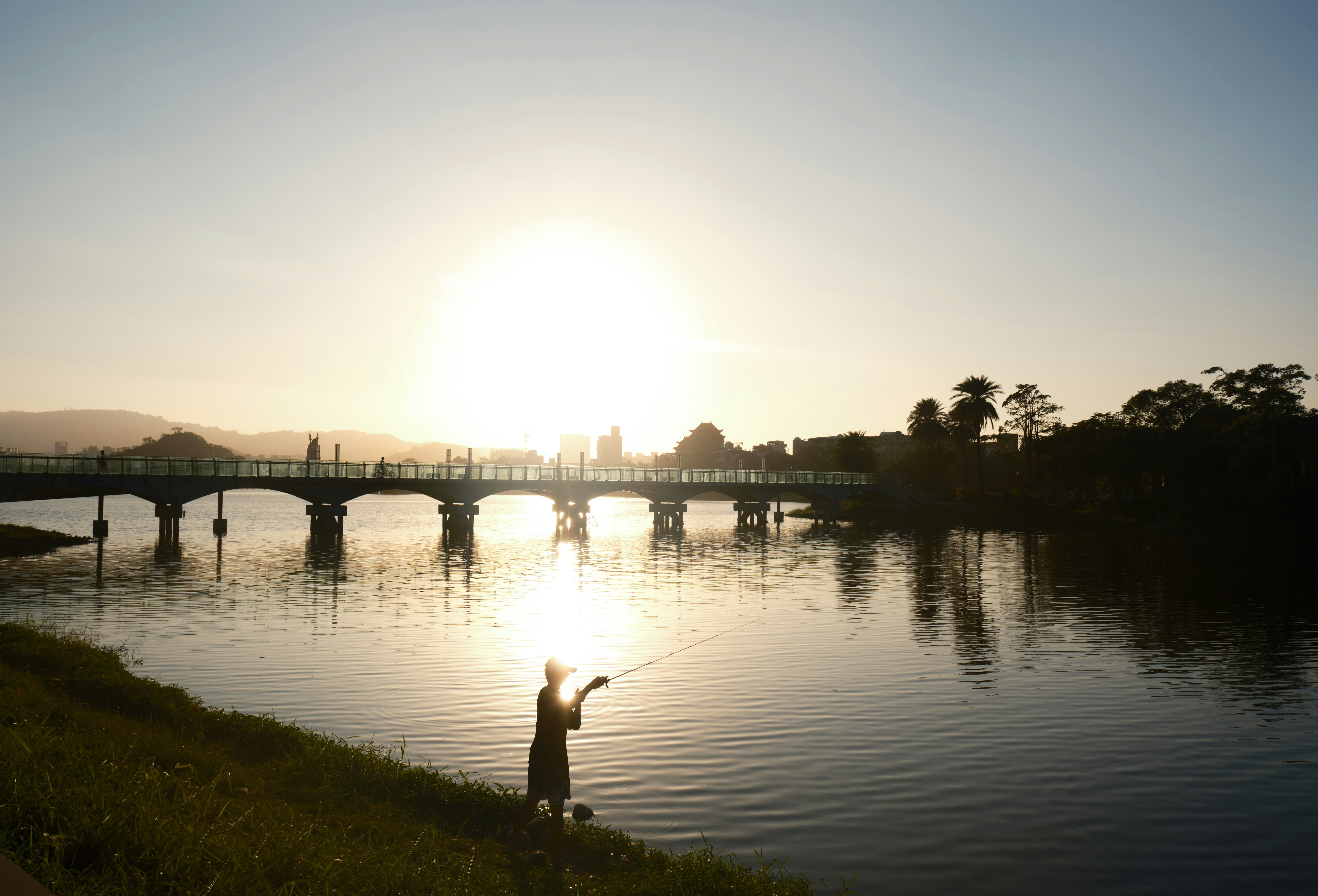 A person standing on the shore of a body of water