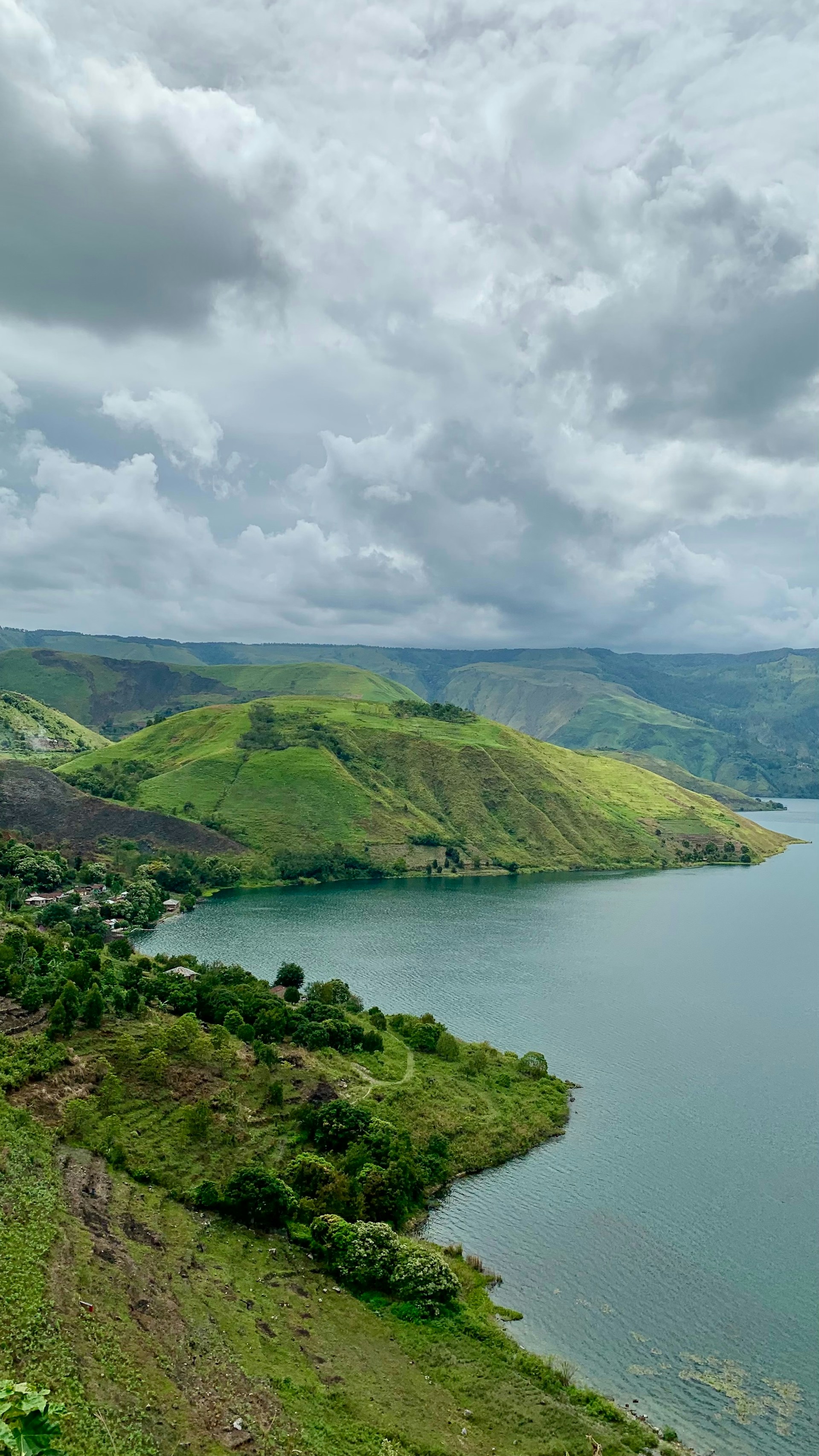 A large body of water surrounded by lush green hills
