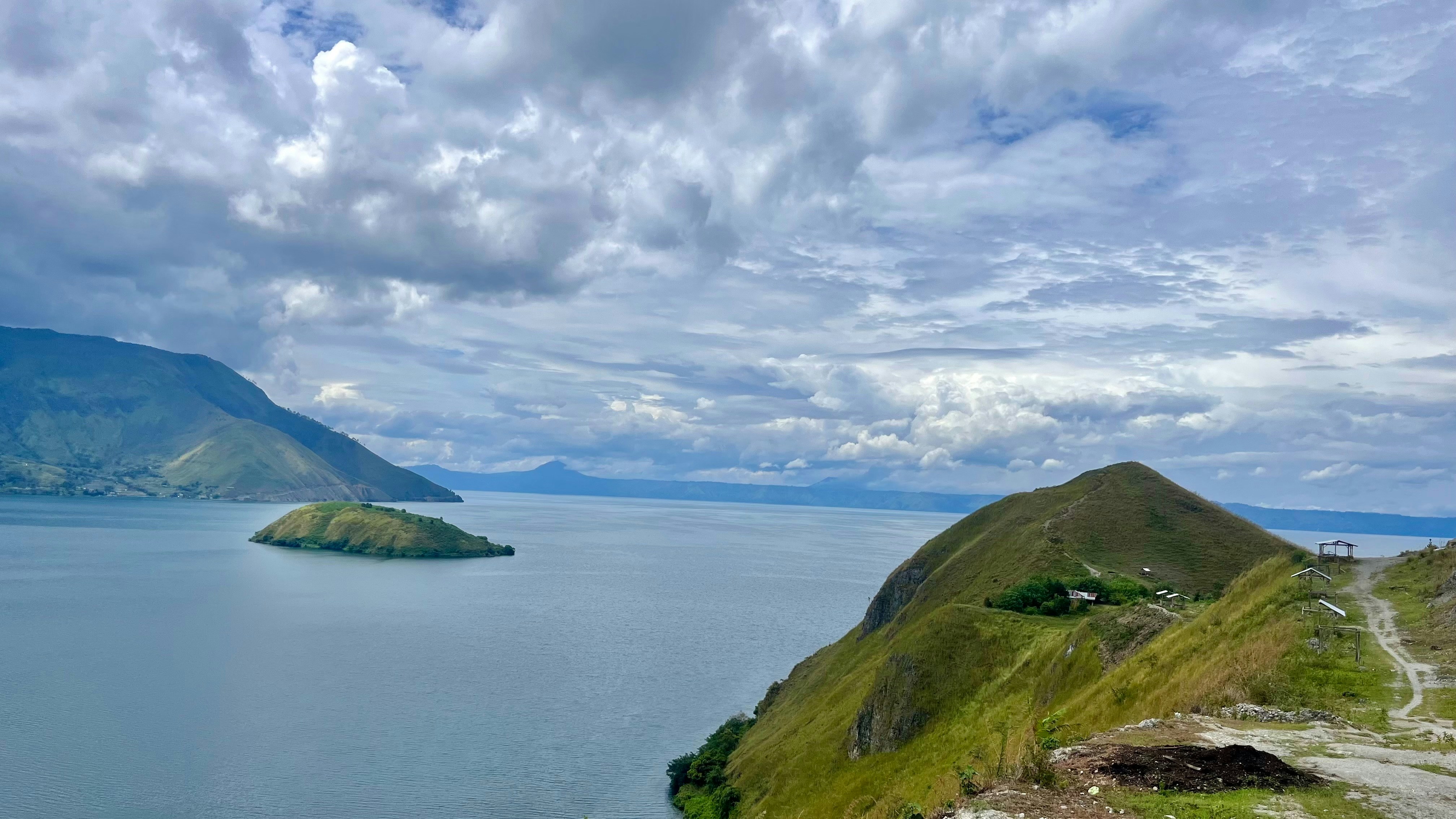 A large body of water sitting next to a lush green hillside