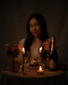A woman sitting at a table with candles in front of her
