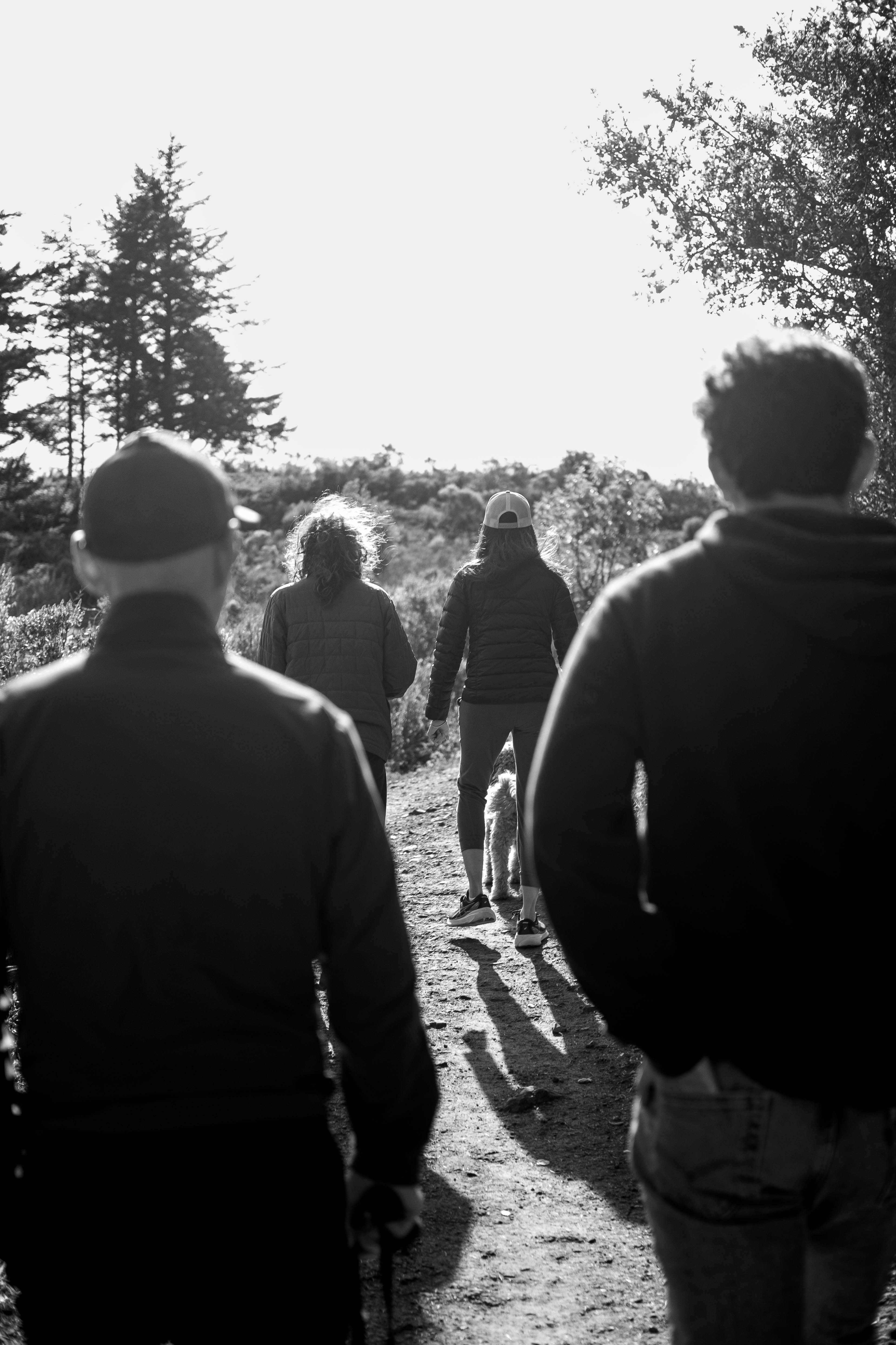 A group of people walking down a dirt road