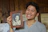 A man holding up a picture of a woman