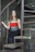 A woman in a red and black dress standing on a set of stairs