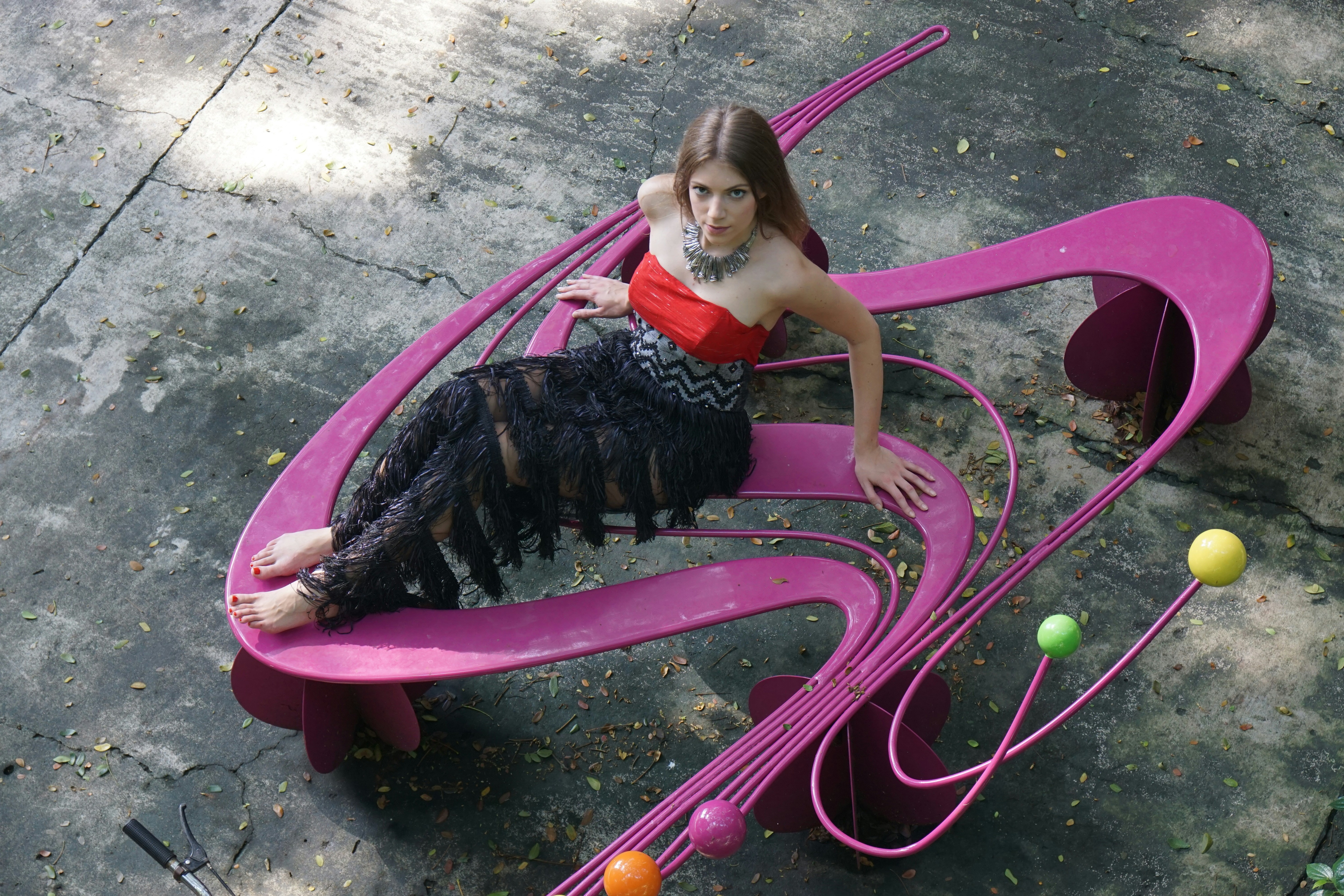 A woman is sitting on a pink bench