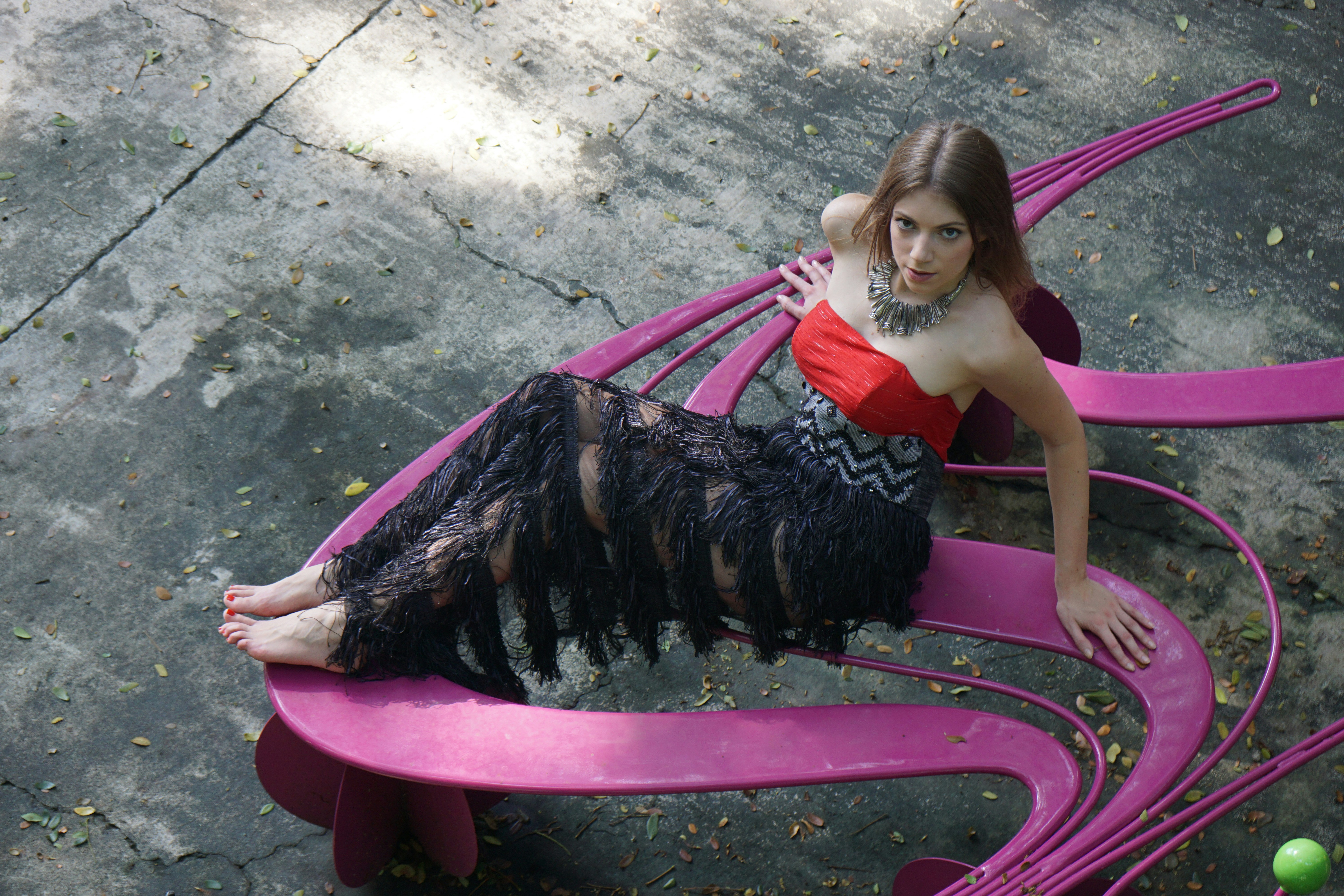 A woman is sitting on a pink bench