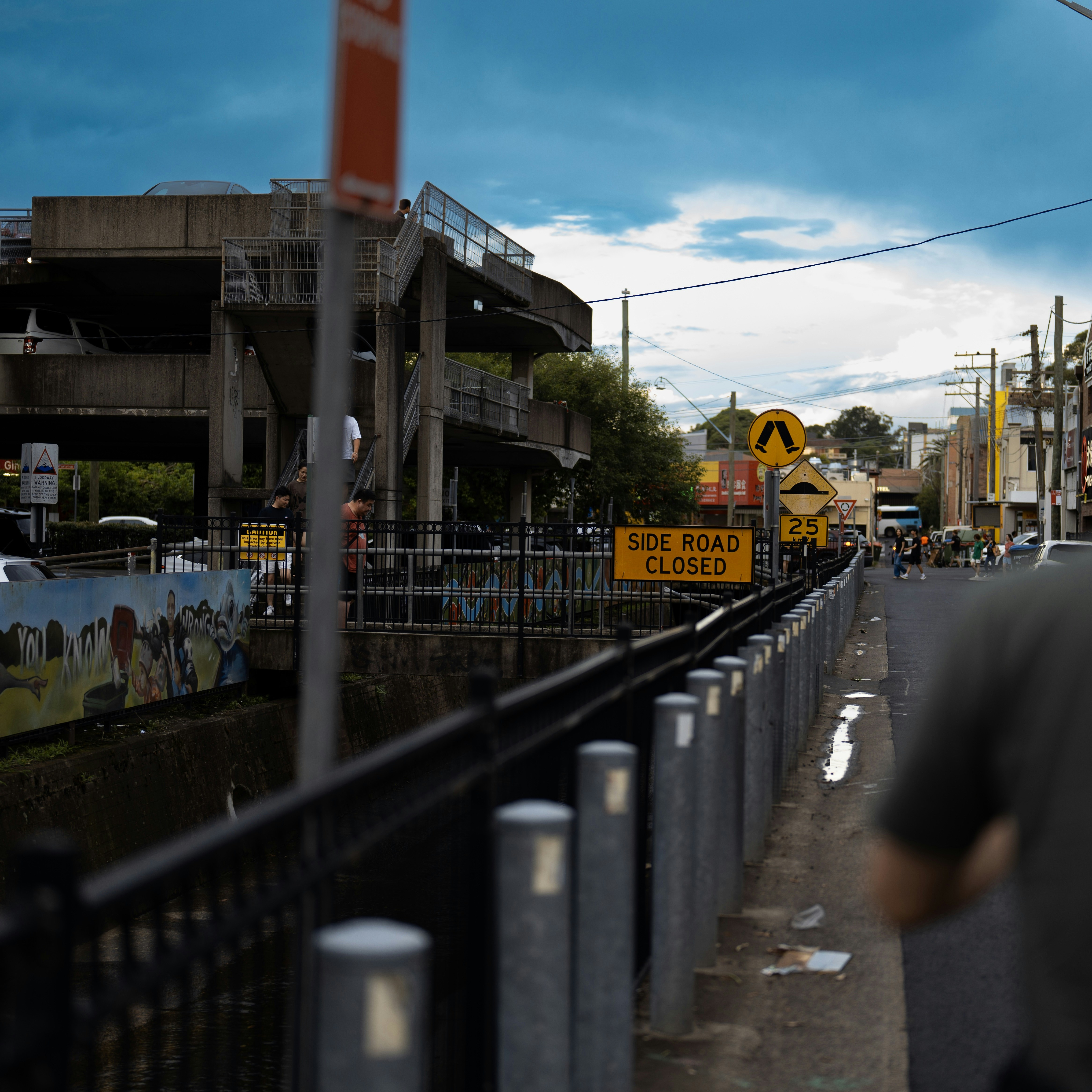 Un hombre caminando por una calle junto a una vía de tren