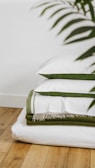 A stack of folded towels on a wooden floor
