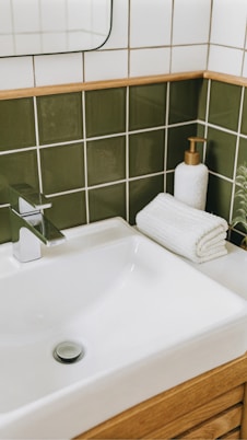 A white sink sitting under a bathroom mirror